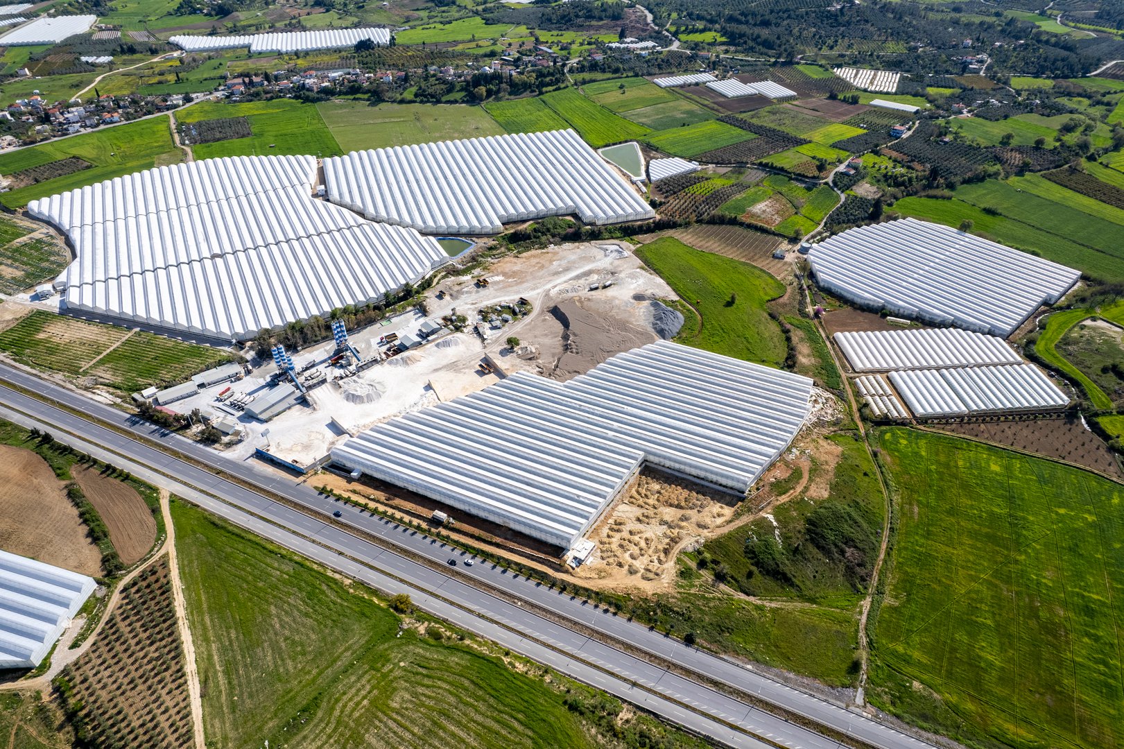 Unsymmetrical view of the sand factory on the side of the intercity road, by drone.