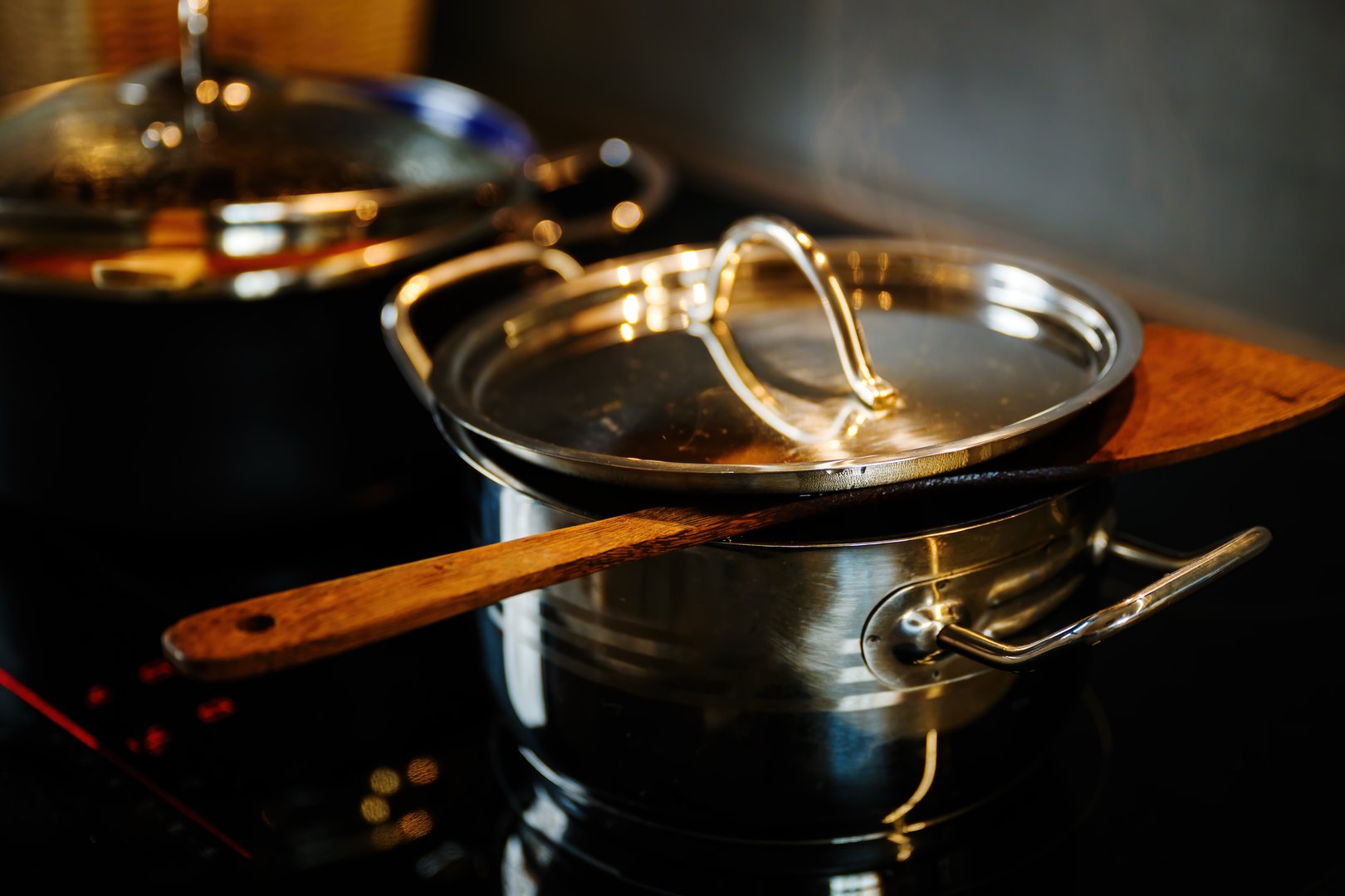 Cooking pots on induction cooktop in the kitchen, food preparation concept, selective focus