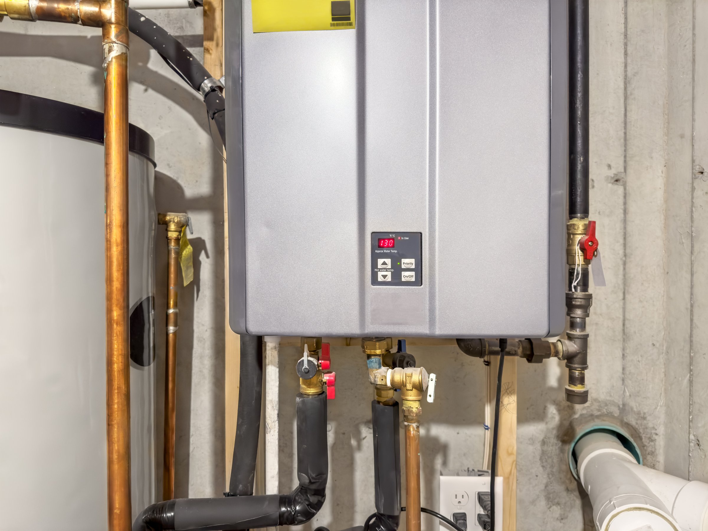 Tankless hot water heater, set to 130° F,  connected to a recirculation system and storage tank