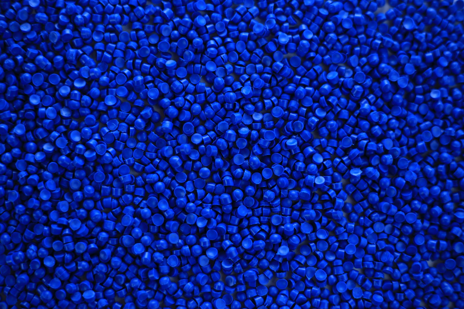 Close-up of blue plastic polymer granules. polymer plastic. compound polymer. PVC resin compounds. Tinted plastic granulate for injection moulding process.