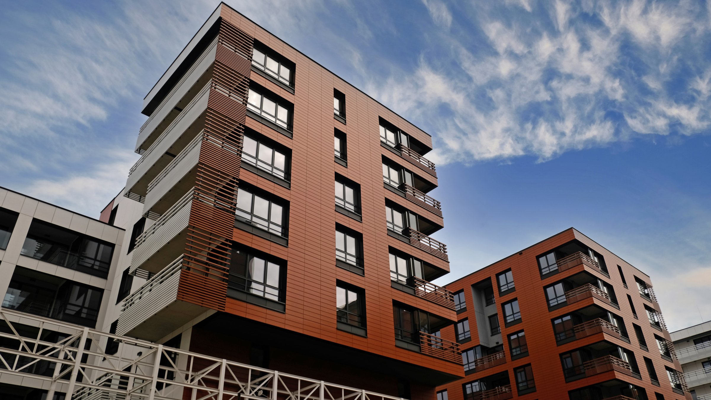 Exterior of modern houses in new area of the city. Architectural detail of windows, balconies. Real estate, residential apartment and office building architecture