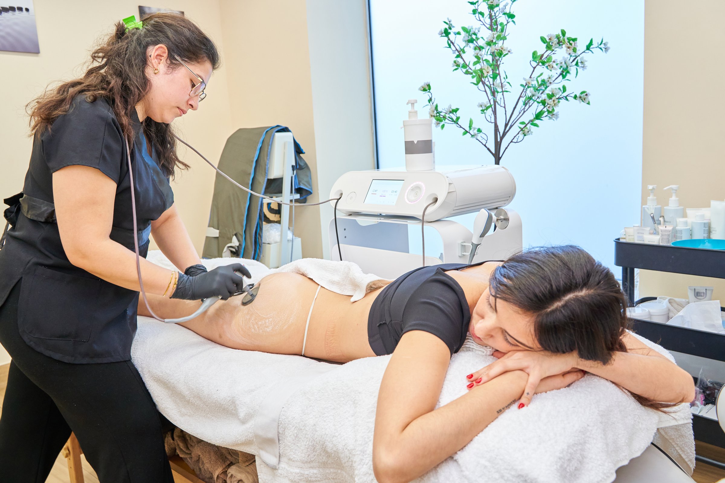 cosmetologist using radiofrequency device and removing stretch marks on female buttocks. Woman having skin tightening procedure in beauty salon. Hardware cosmetology concept.