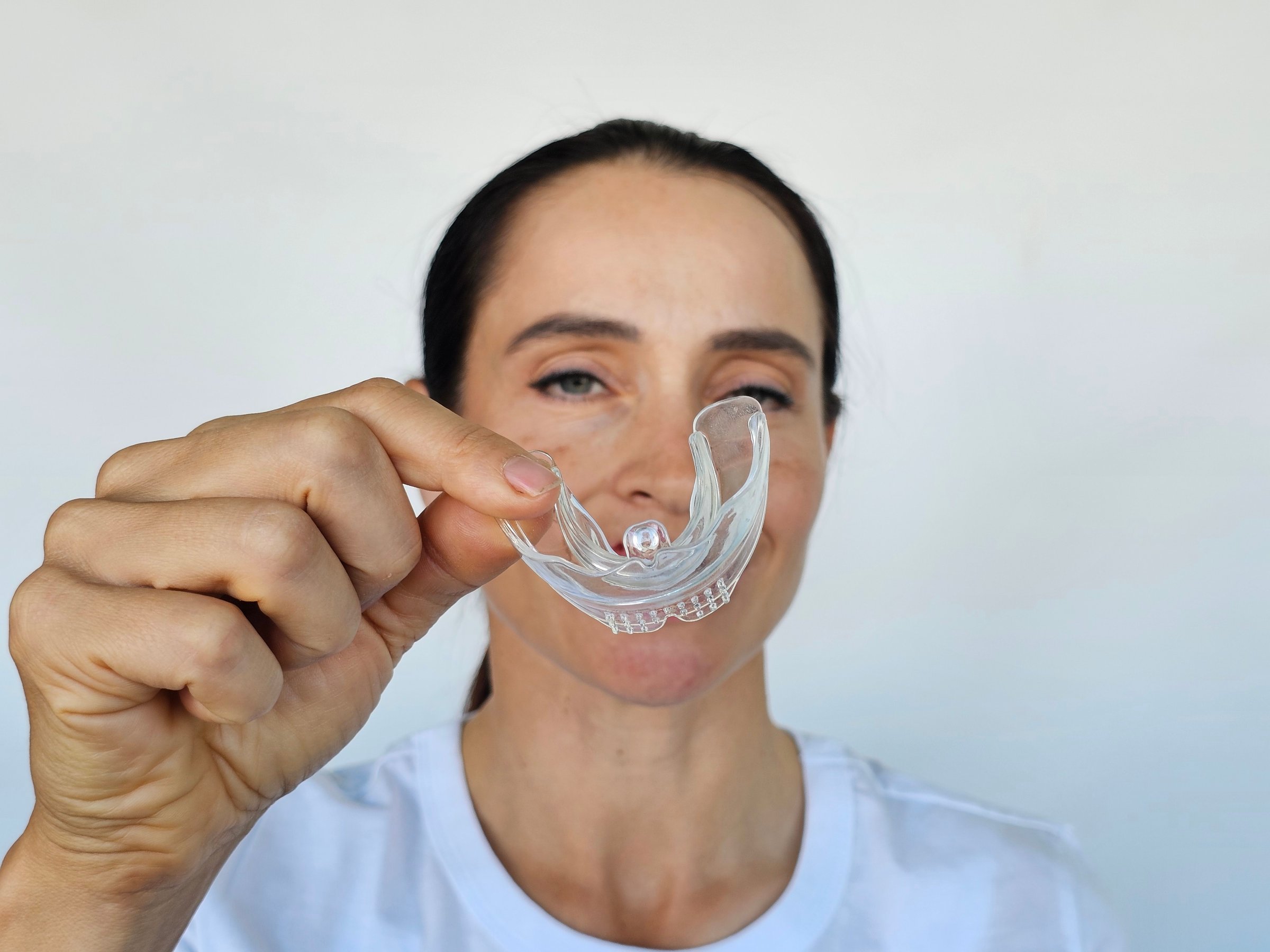 Smiling woman with transparent plastic mouth guard