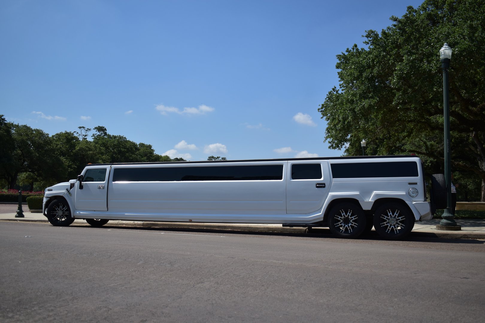 Houston, TX USA, Summer 05/08/2023 -Portrait of a custom Hummer H2 stretch limousine within a beautiful landscape at Hermann Park in Houston, TX