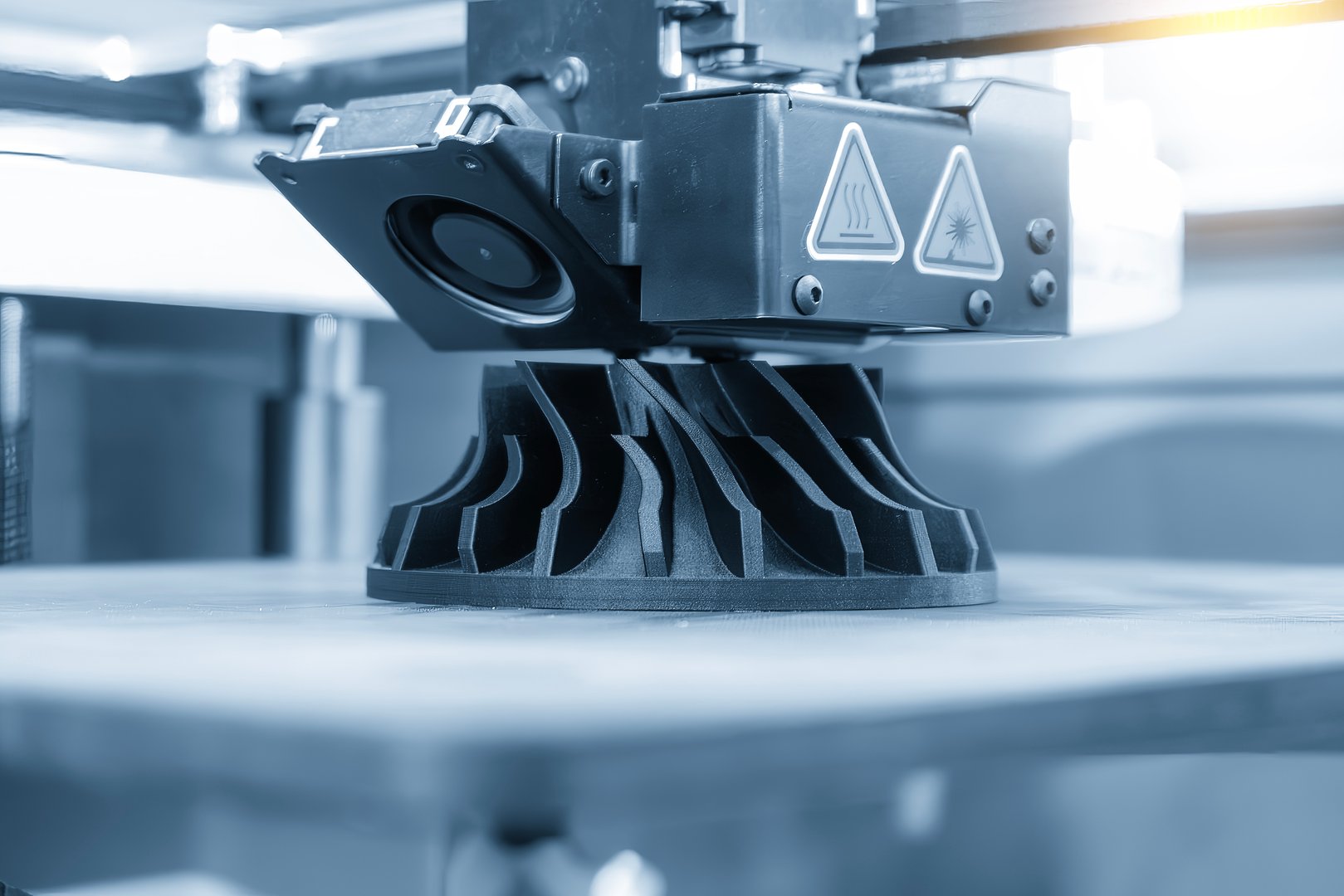Close up scene the additive manufacturing by 3D printer machine in the light blue scene. The high technology manufacturing process by rapid prototype method.