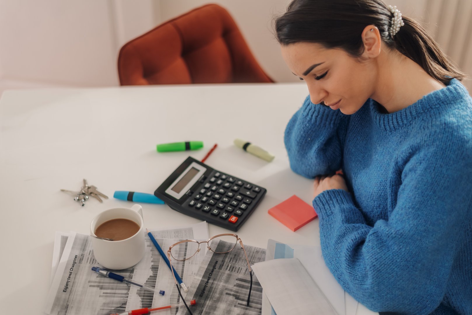 Young woman working from home having a bad headache and feeling stressed while calculating domestic expenses