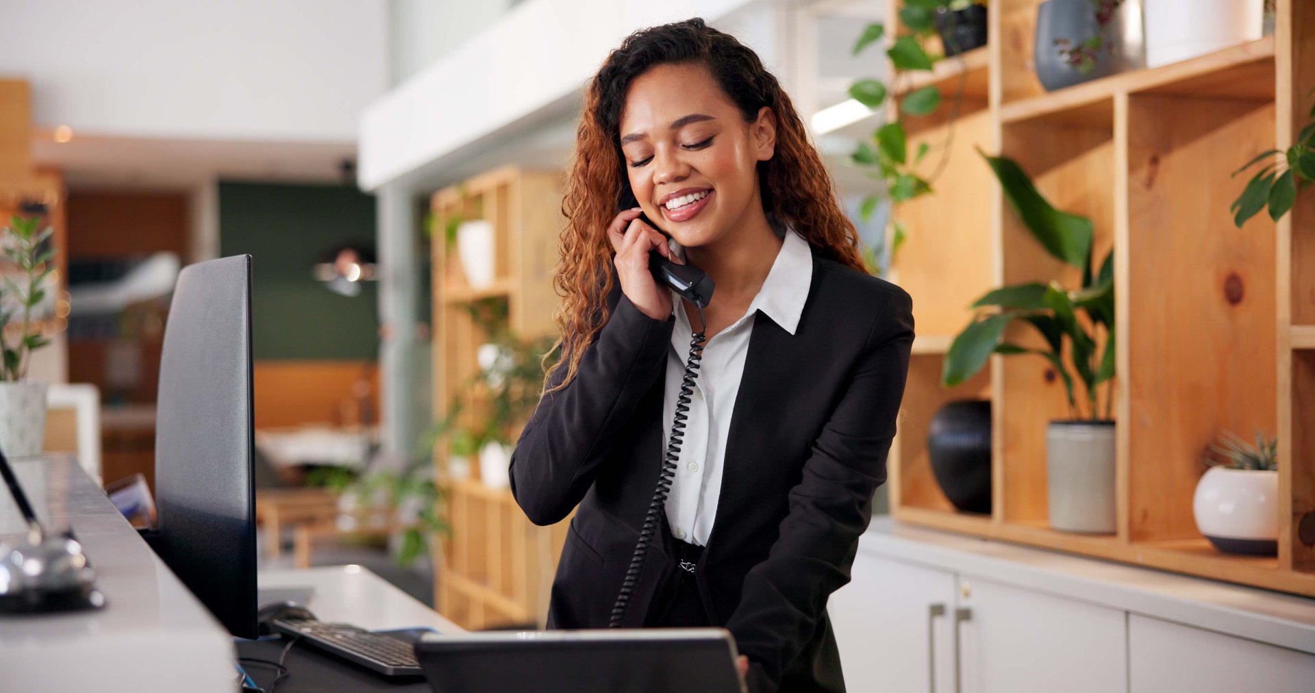 Hotel, reception and call of concierge consultant with African woman, customer care and hospitality enquiry for villa. Staff, service and question at lobby desk with conversation, helping and support