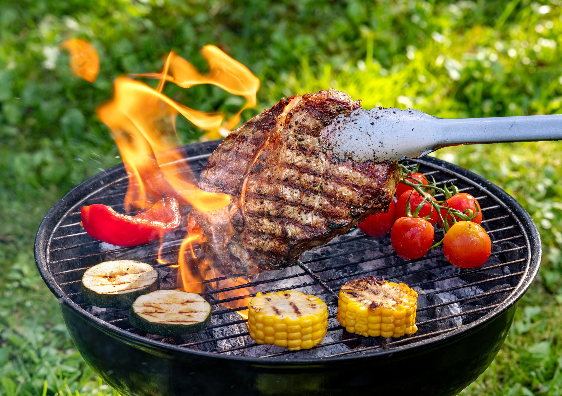 freshly grilled beef steak and vegetables on charcoal grill