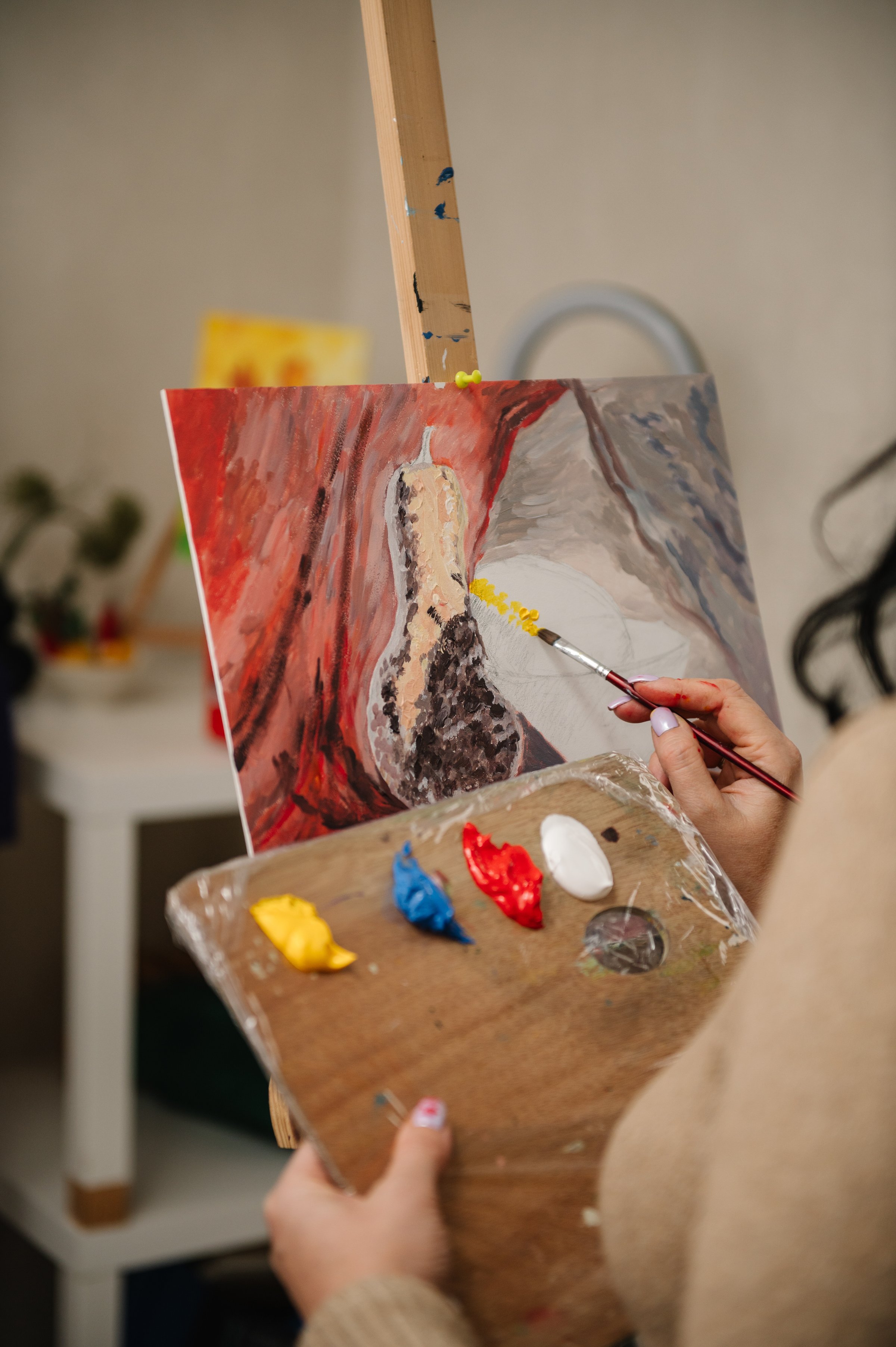 Mujer pintando en un taller. Dibujando con pincel en caballete