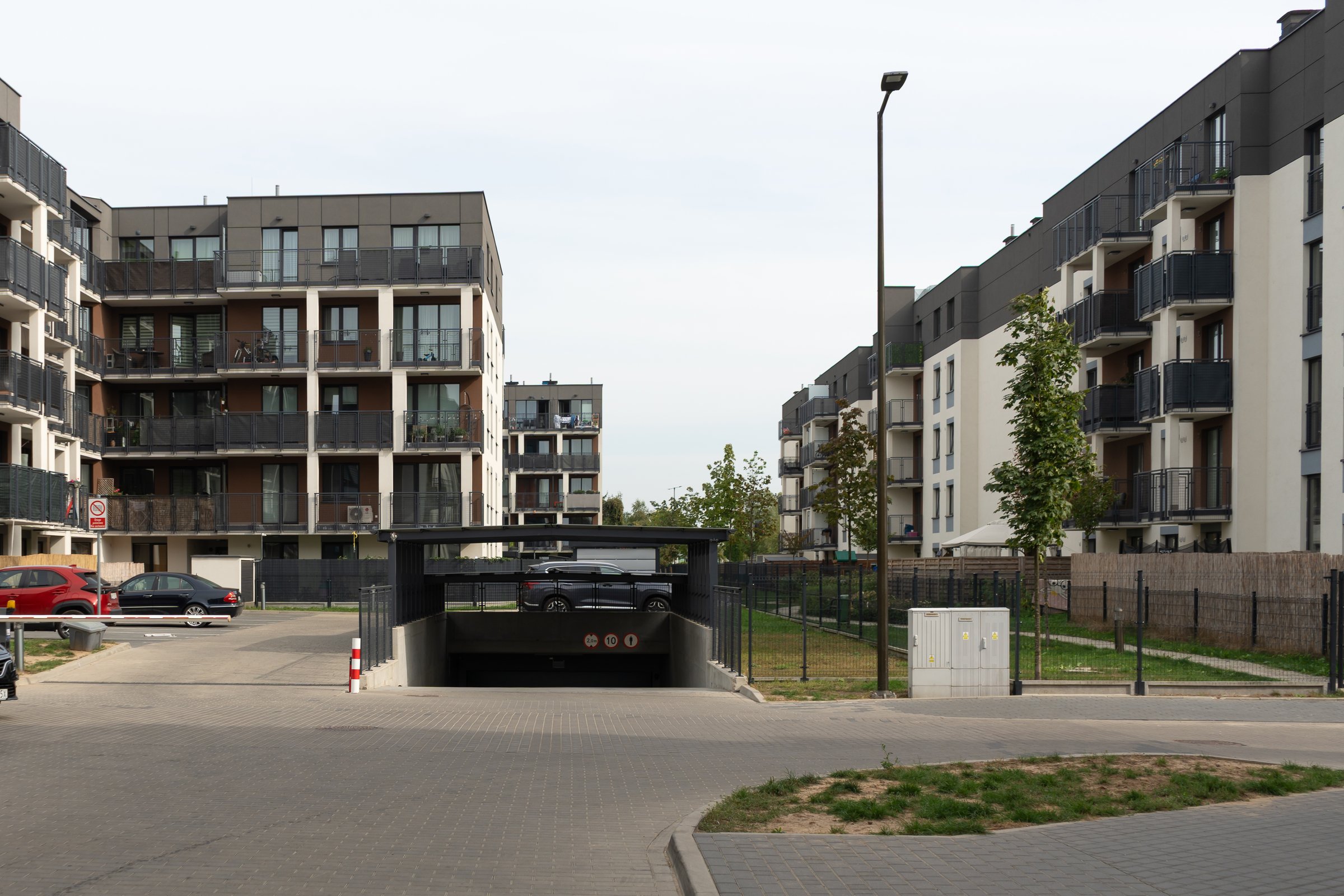 The entrance to an underground parking garage at a new apartment complex in Warsaw. This is a modern solution for vehicle storage in a residential real estate development.
