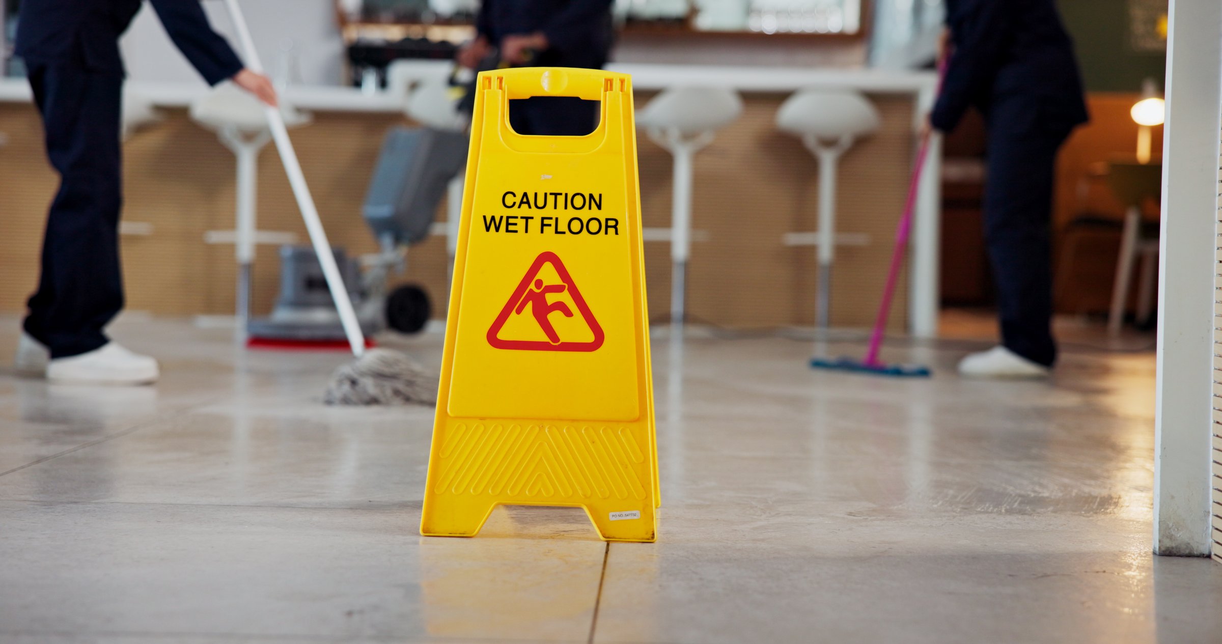 Cleaning, warning and caution for wet floor, sign and people with equipment for disinfection or mop. Board, info and team with tools for sanitation of coffee shop, routine and service in business