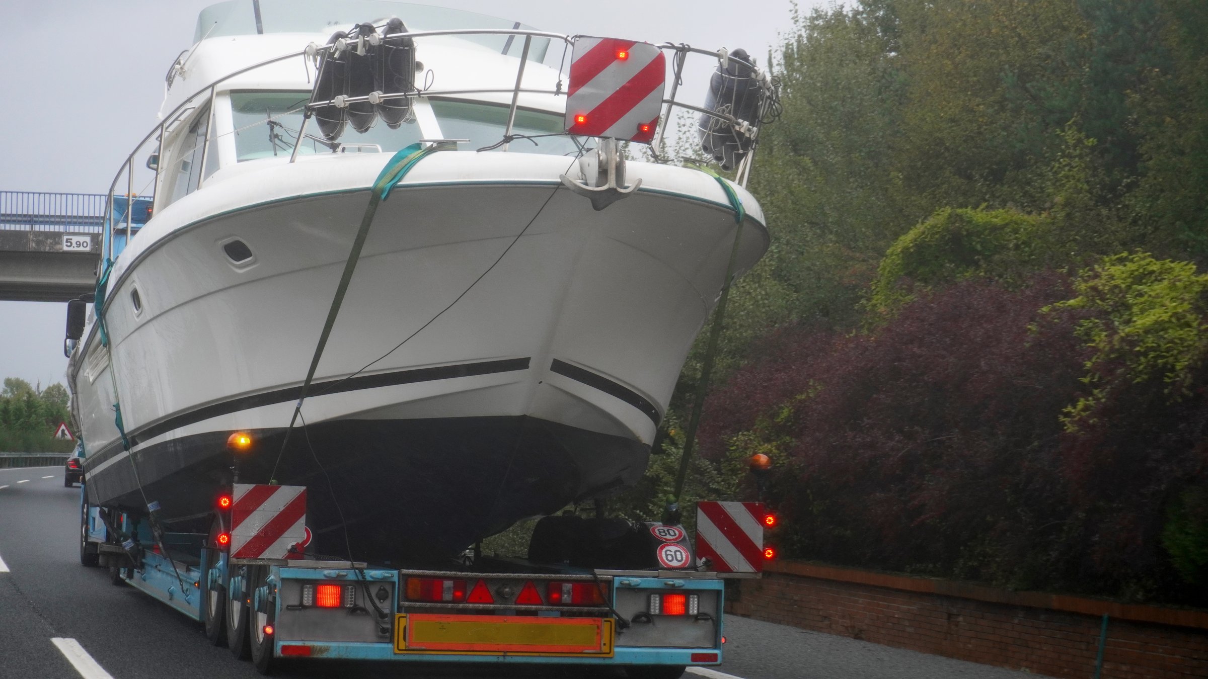 truck loaded with a large yacht, circulates on the highway