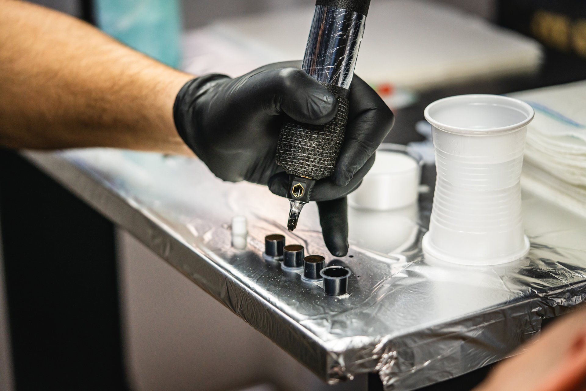 Tattoo artist preparing colors and machine in professional studio