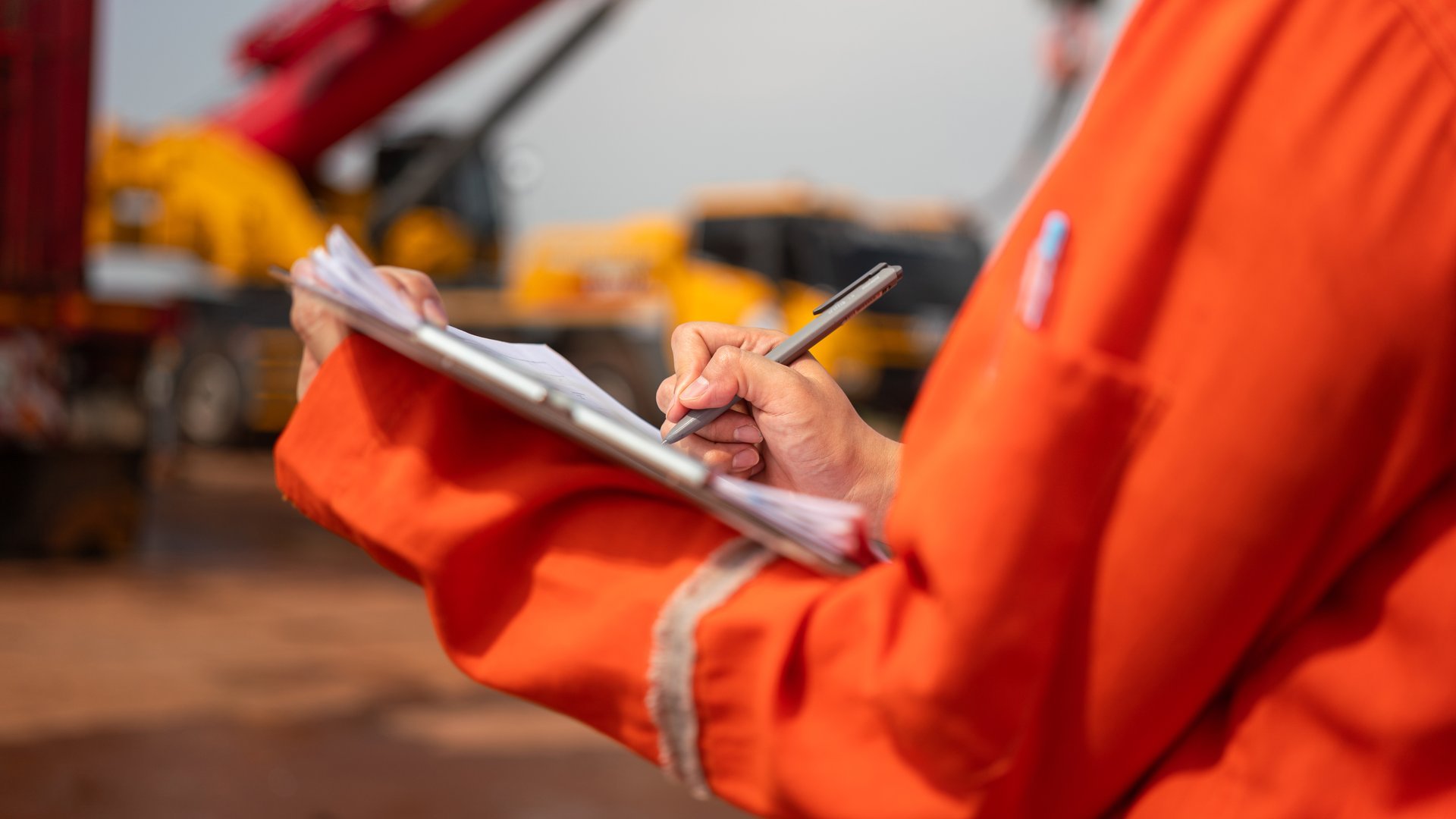 An engineer or foreman is checking on safety checklist form of lifting crane at the drilling rig work site. Industrial safe working concent, close-up and selective focus.