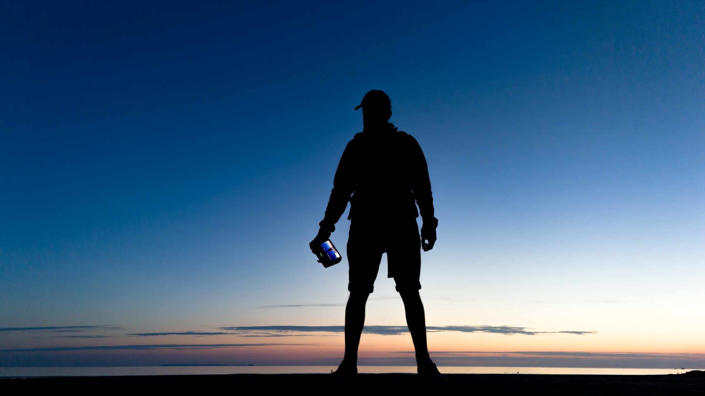 Drone operator on the beach at sunset