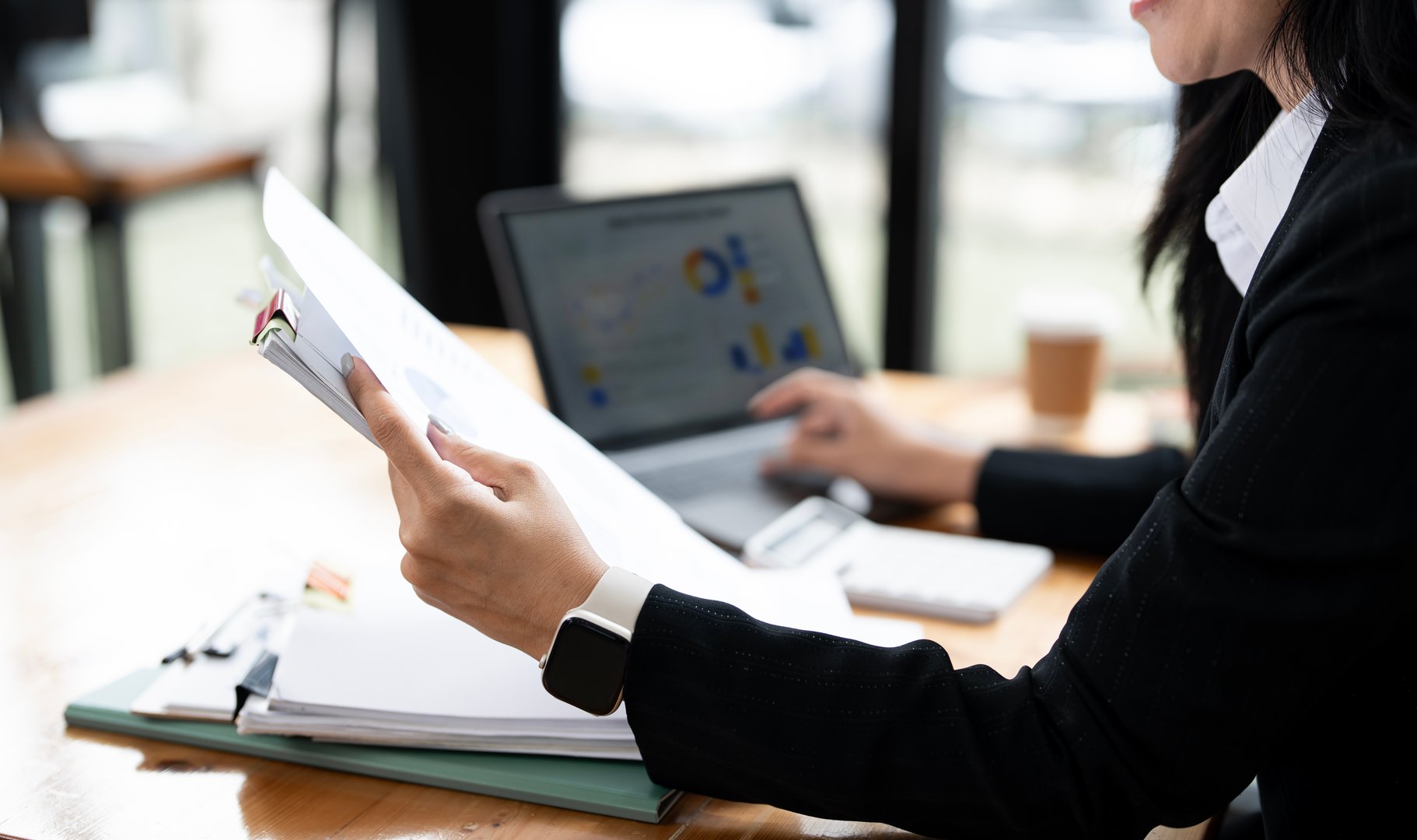 Business woman using laptop for do math finance paperwork on wooden desk in office and business working background, tax, accounting, statistics and analytic research concept.