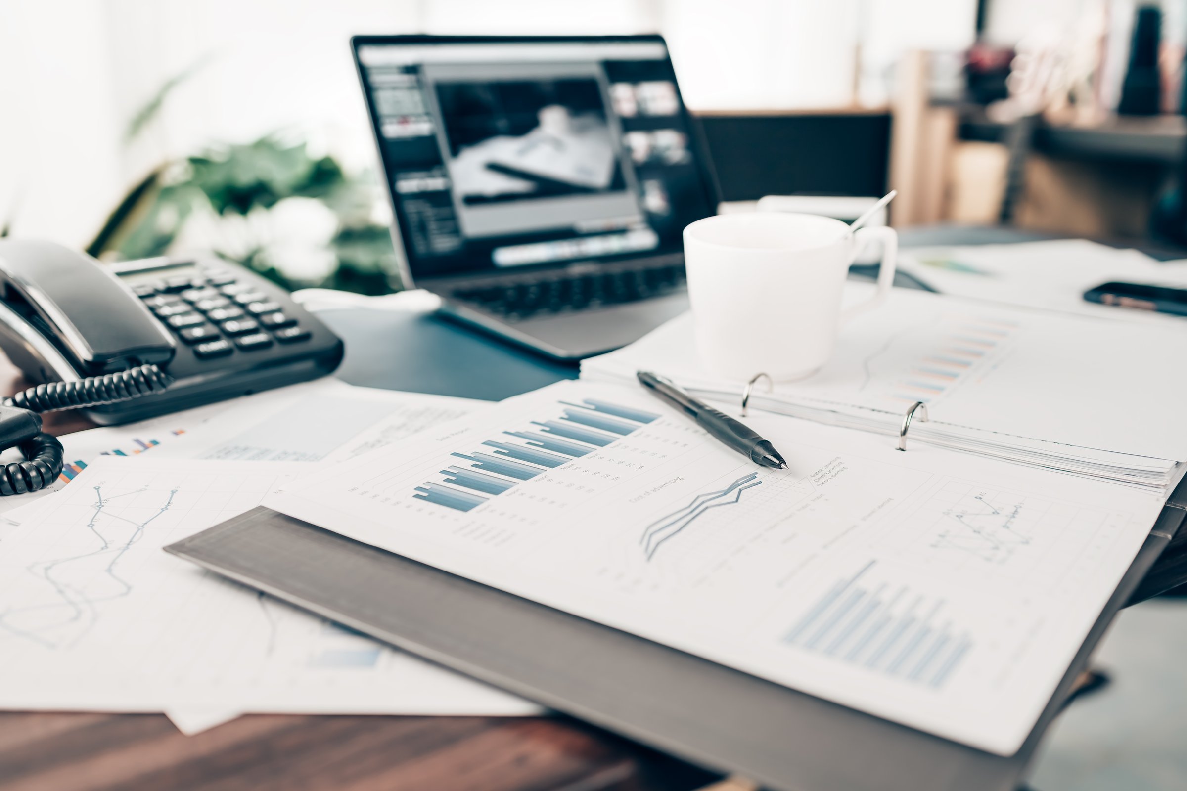 A pen on data sheet and Businessman working on office desk and analyzing new project of accounting finance. Investment, Financial advisor and accounting concept.