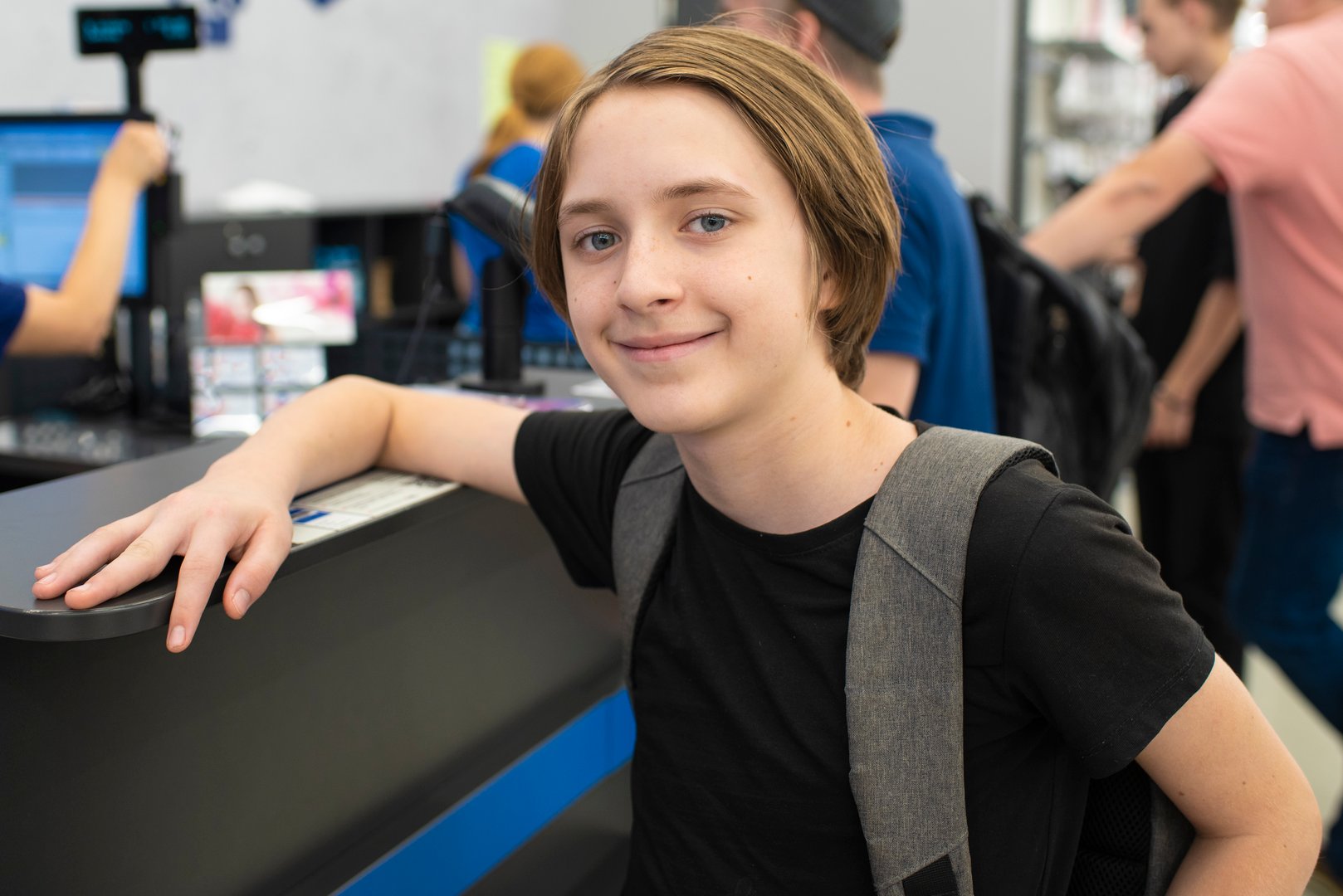 teenage boy standing in a store near the checkout