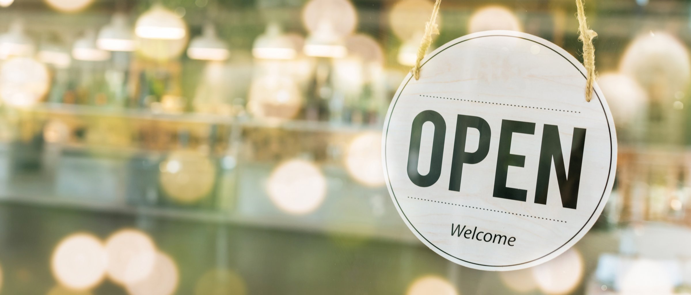 Open sign hanging front of coffee cafe shop door