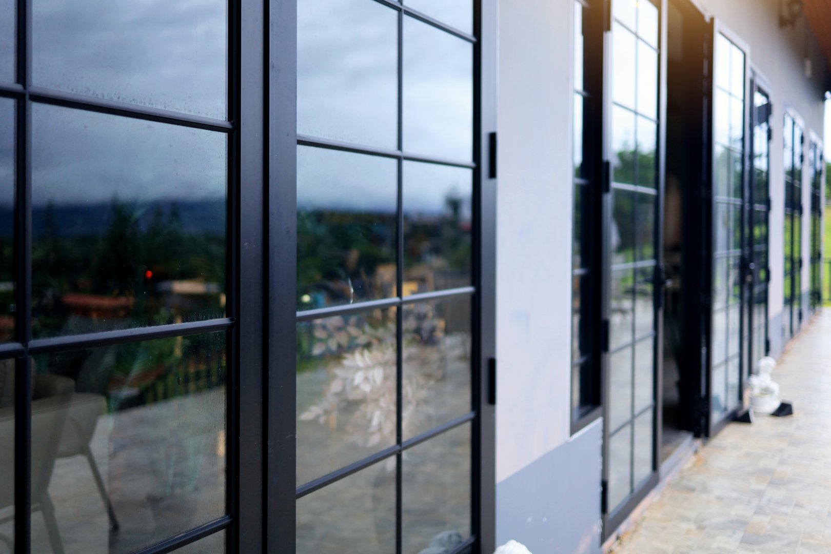 Angled view and exterior decoration with glass door and black tone metal frame background.