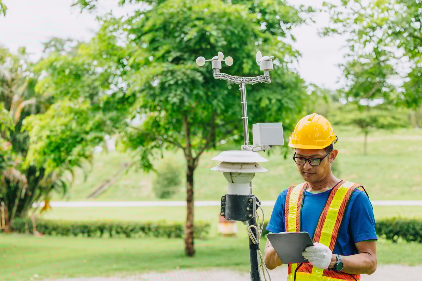 Technician male working collecting Air pollution, Weather monitor, Wind information data from sensor station outdoor