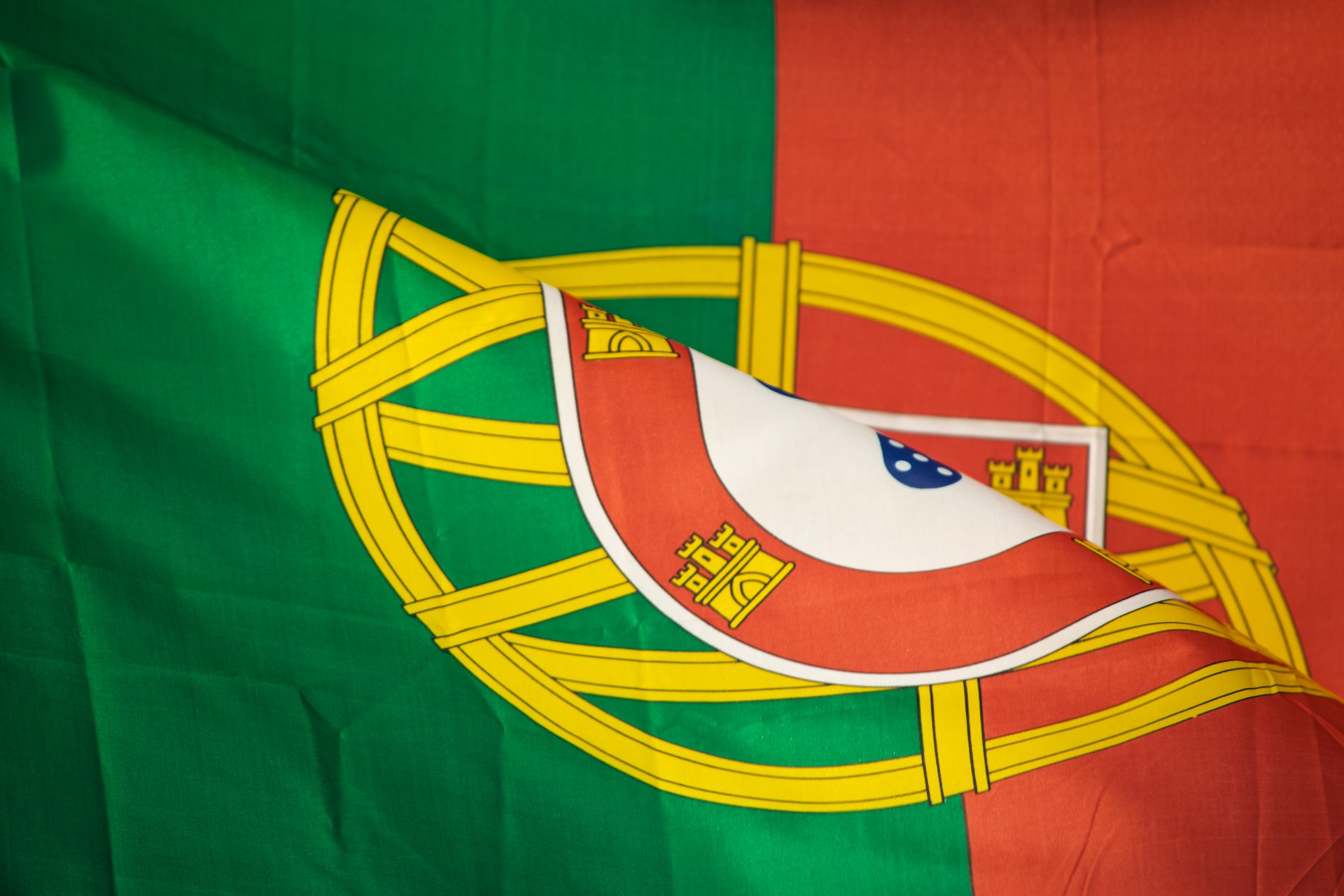 detail view of the flag of portugal and national emblem