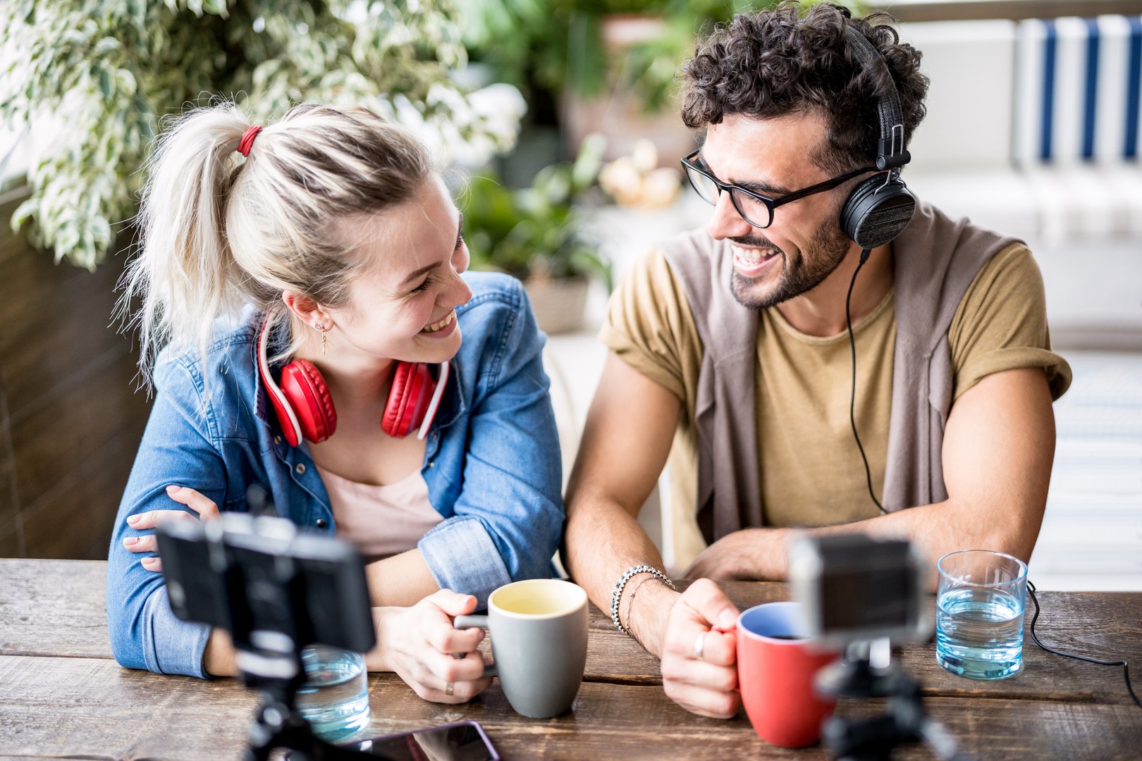 Young millenial couple sharing creative content online on webcam - Digital marketing concept with next generation influencer having fun on radio video stream - Vlogging time at startup coworking space