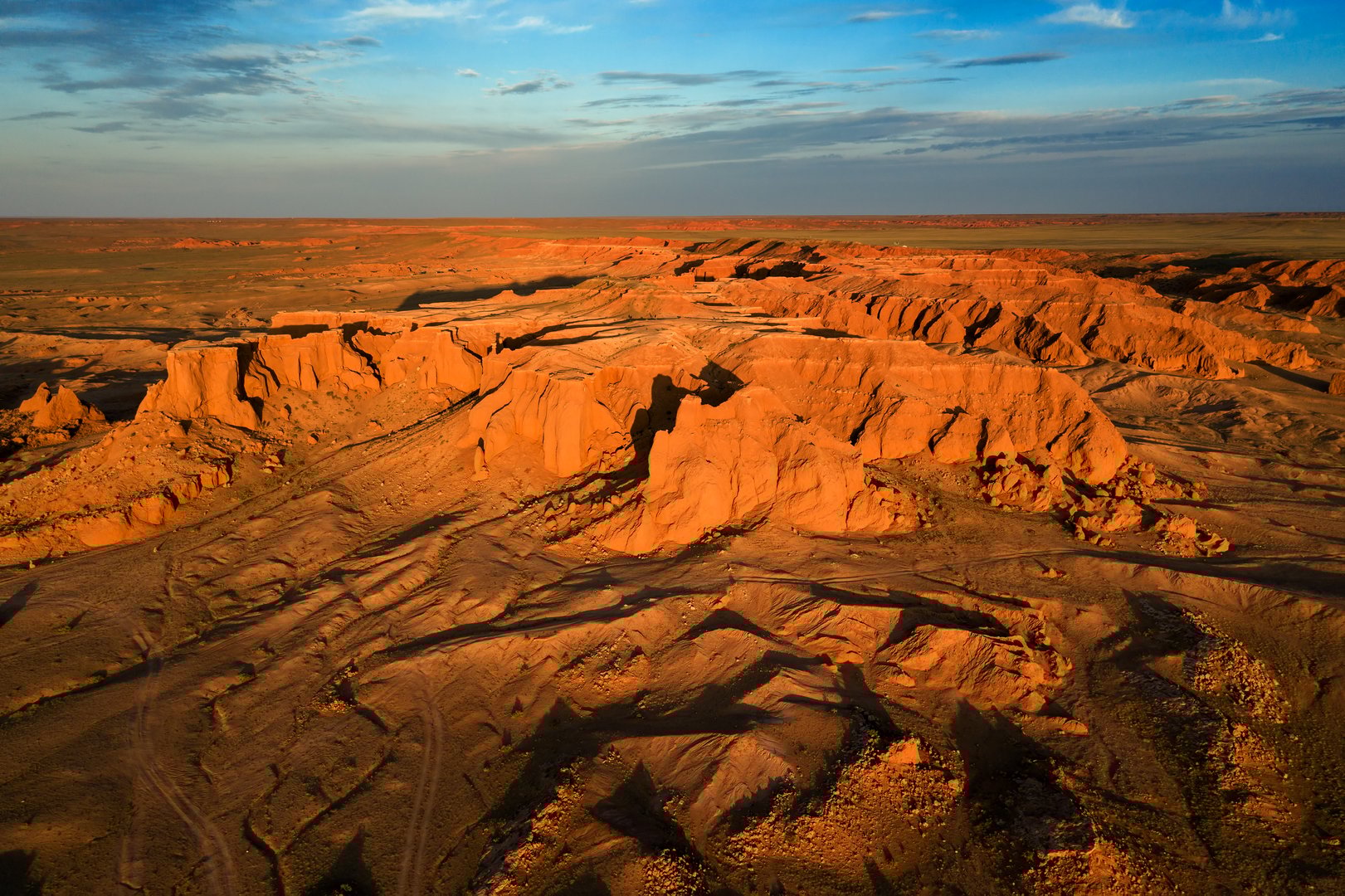 Aerial view of the Bayanzag flaming cliffs at sunset in Mongolia, found in the Gobi Desert
