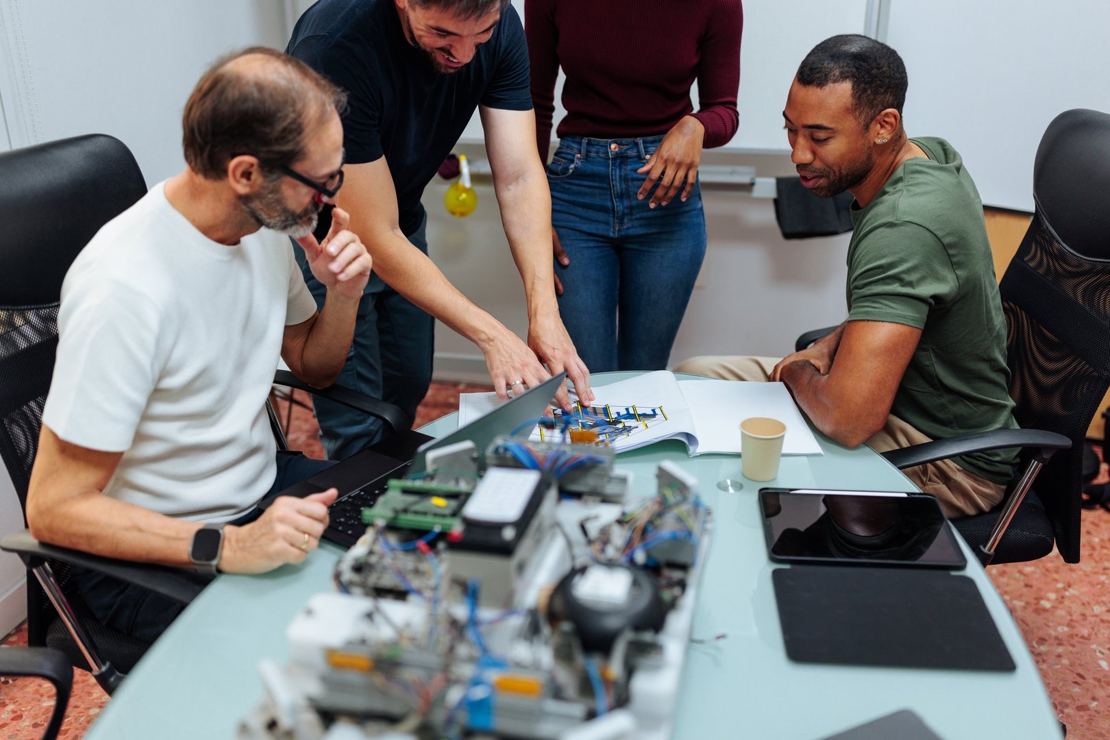 Engineers analyzing blueprints and components, developing a cutting-edge robotics project in a technologically advanced workspace