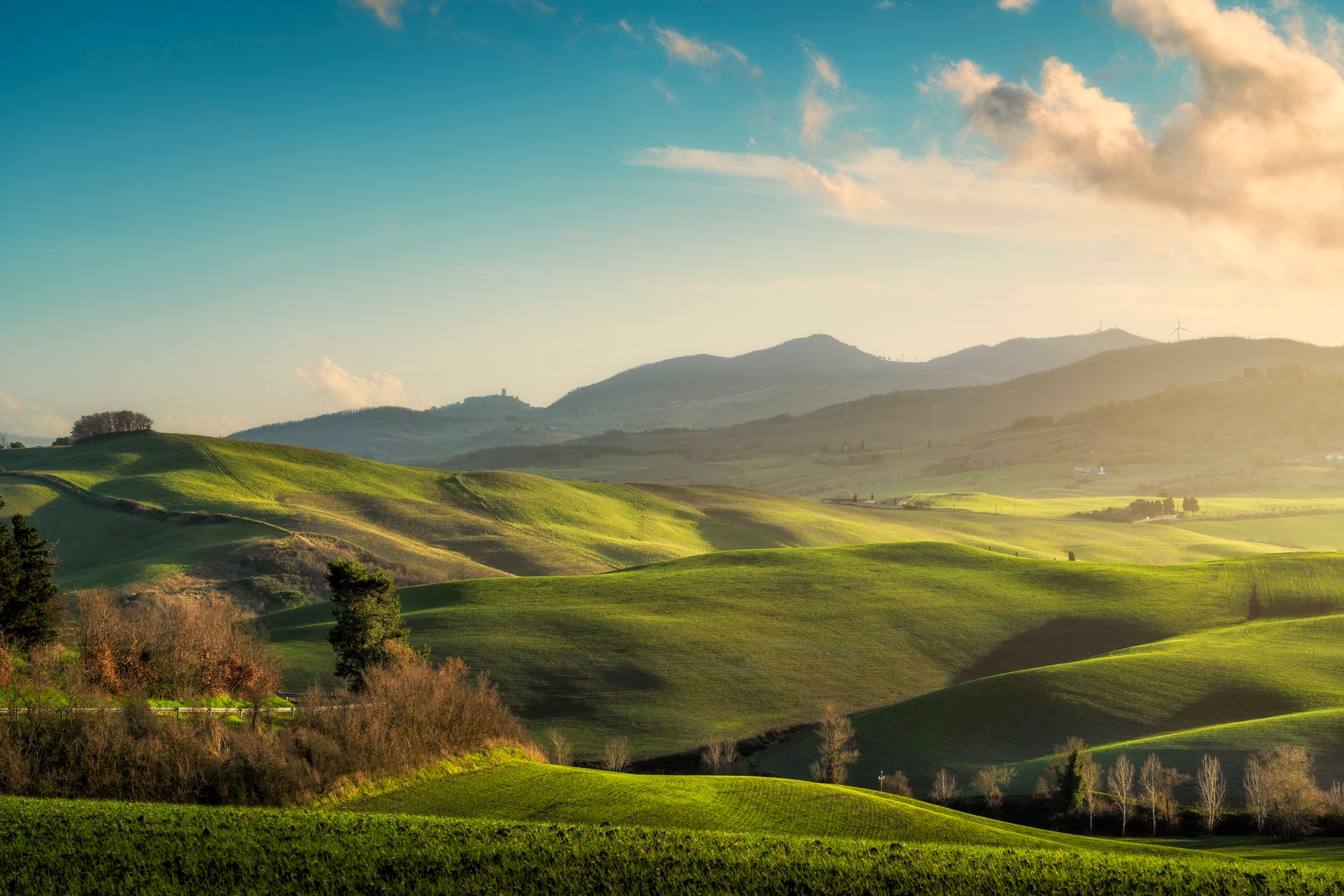 Landscape of hills at sunset in the countryside of Lajatico. Montecatini Val di Cecina village in the background. Province of Pisa, Tuscany region, Italy