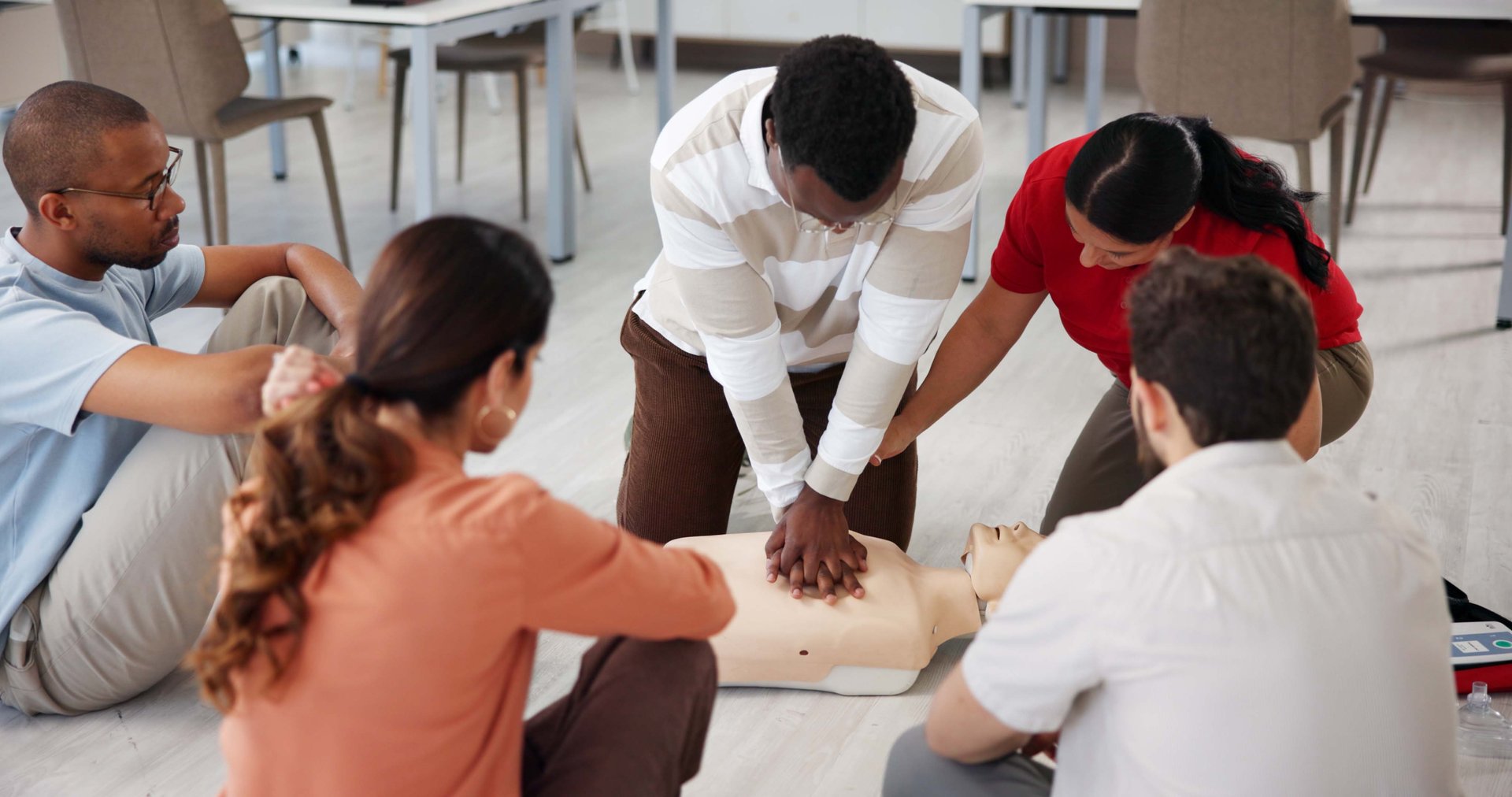People, dummy and first aid in office for learning, CPR workshop or chest compression lesson.