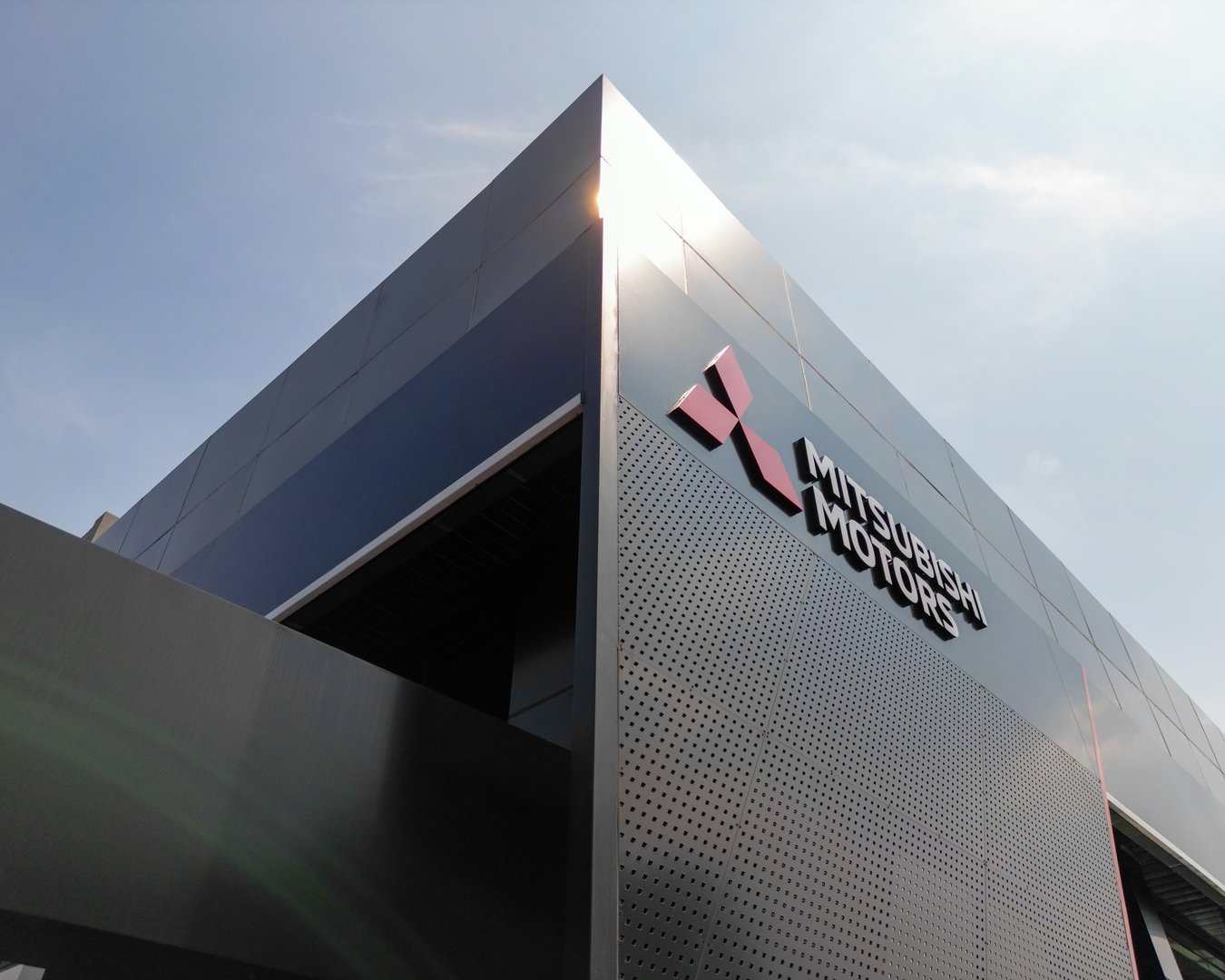 Jakarta, Indonesia - June 8, 2023: Aerial low angle Mitsubishi motors signboard over blue sky background.
