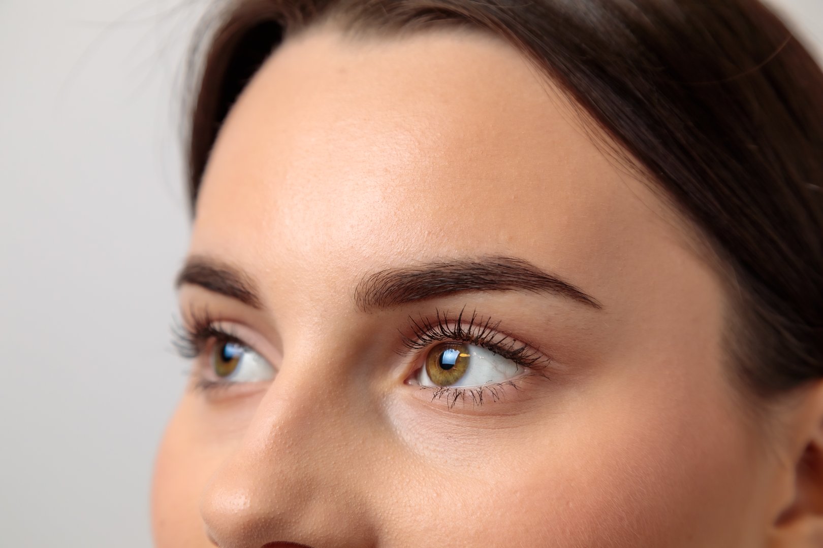 Close-up of beautiful woman with perfect eyebrows after microblading treatment, highlighting the precision and artistry of cosmetic enhancements