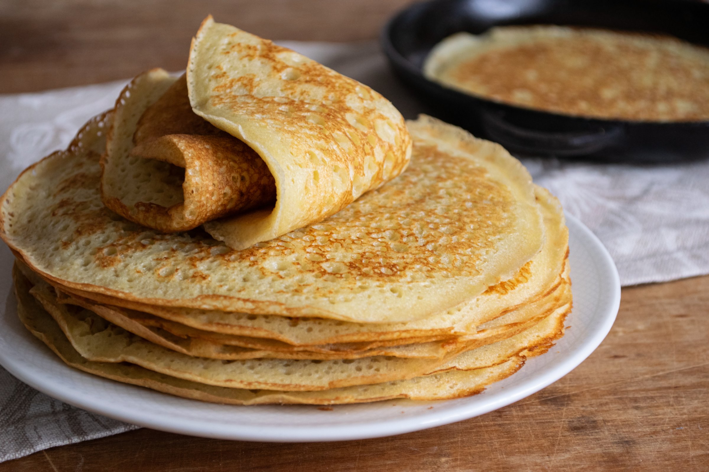 Crepes (Russian Blini) on wooden background, top view. Homemade thin fresh crepes for breakfast