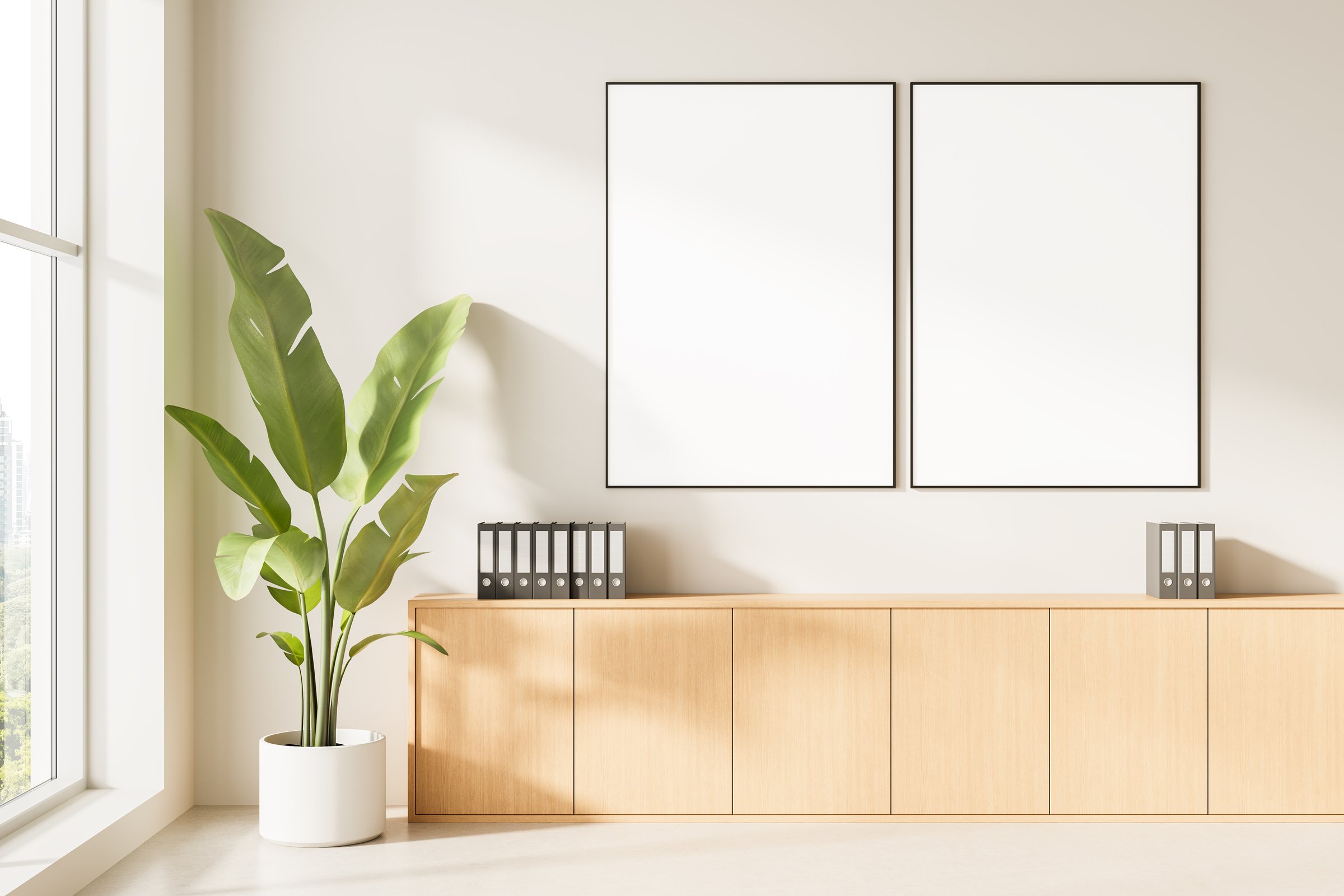 Bright modern interior with wooden cabinet, green plant, two blank posters and folders, minimalistic design on neutral background. 3D Rendering