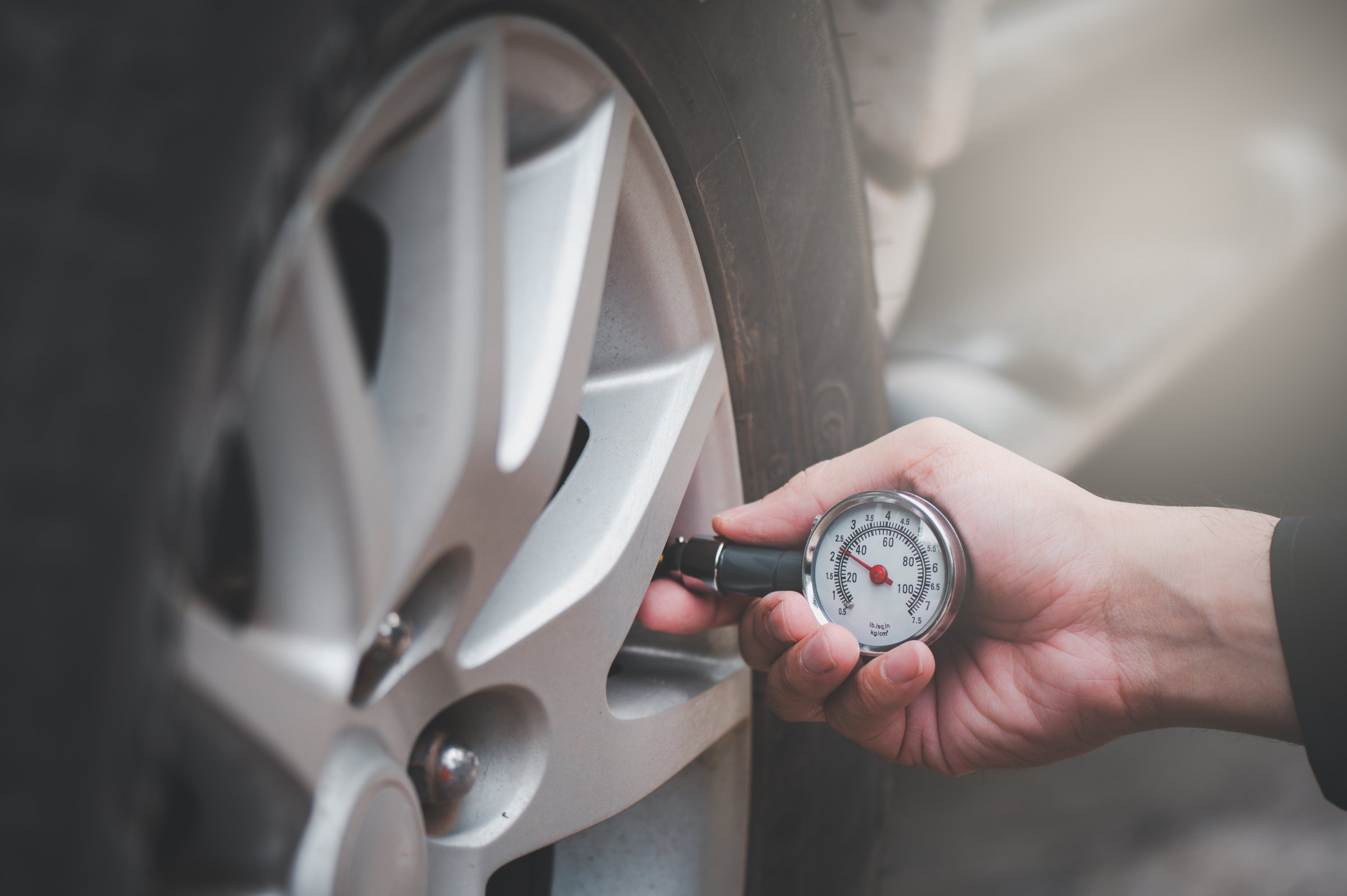 Tire pressure gauge : Hand holding pressure gauge checking air pressure for car tire.