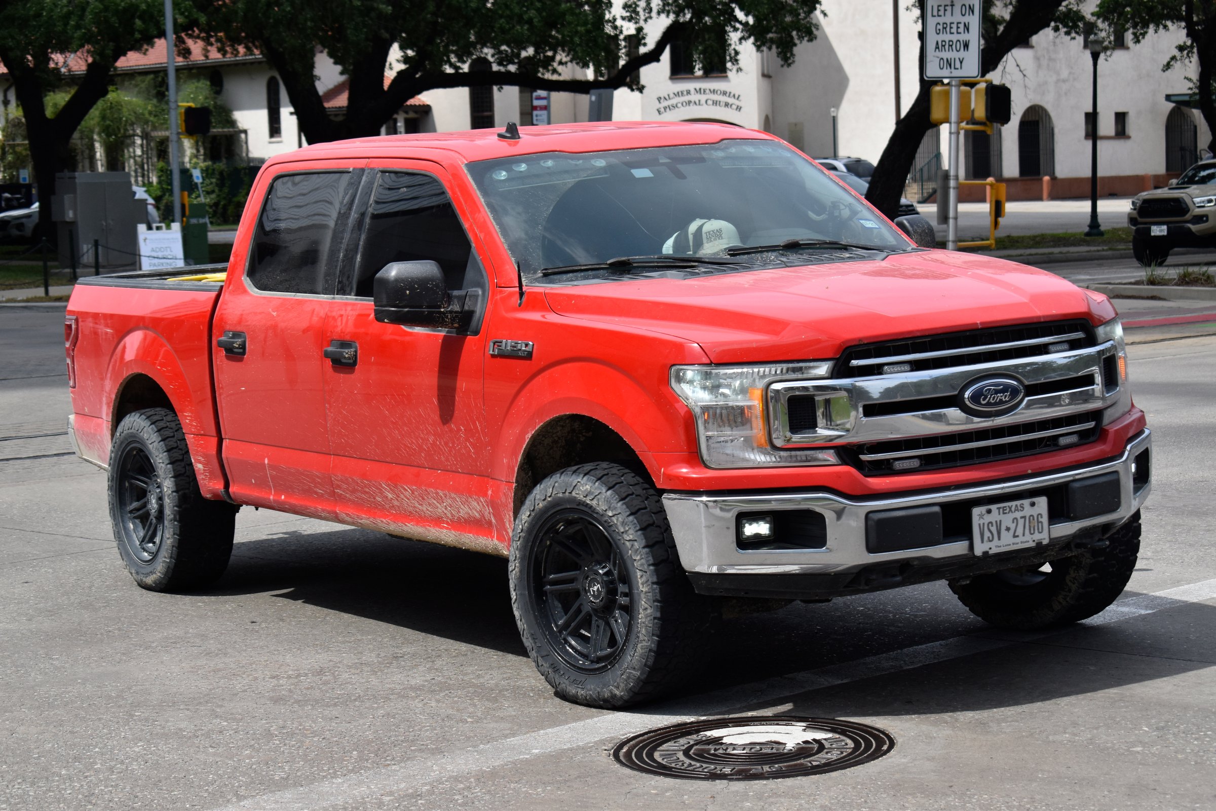 Houston, TX USA -  A portrait of a red Ford F-150 pick-up truck cruising in a downtown district