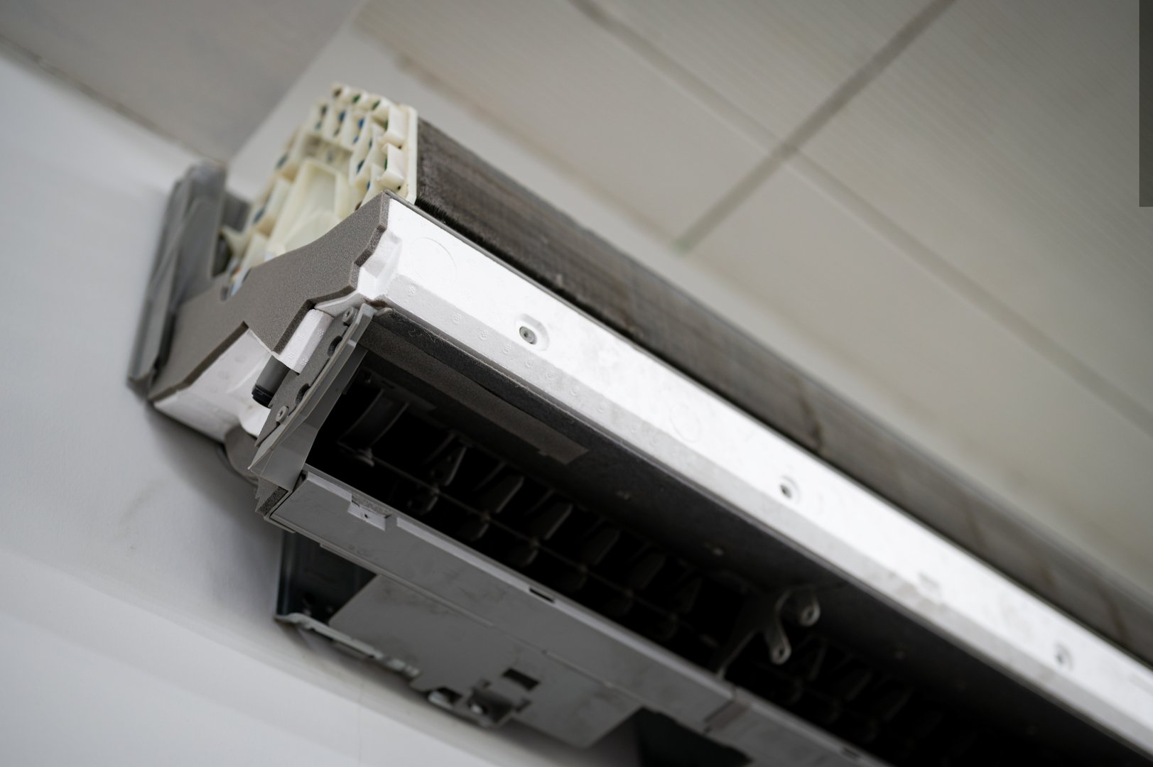 Air conditioning service. Technician fixing air conditioner indoors. Repair and maintenance concept.