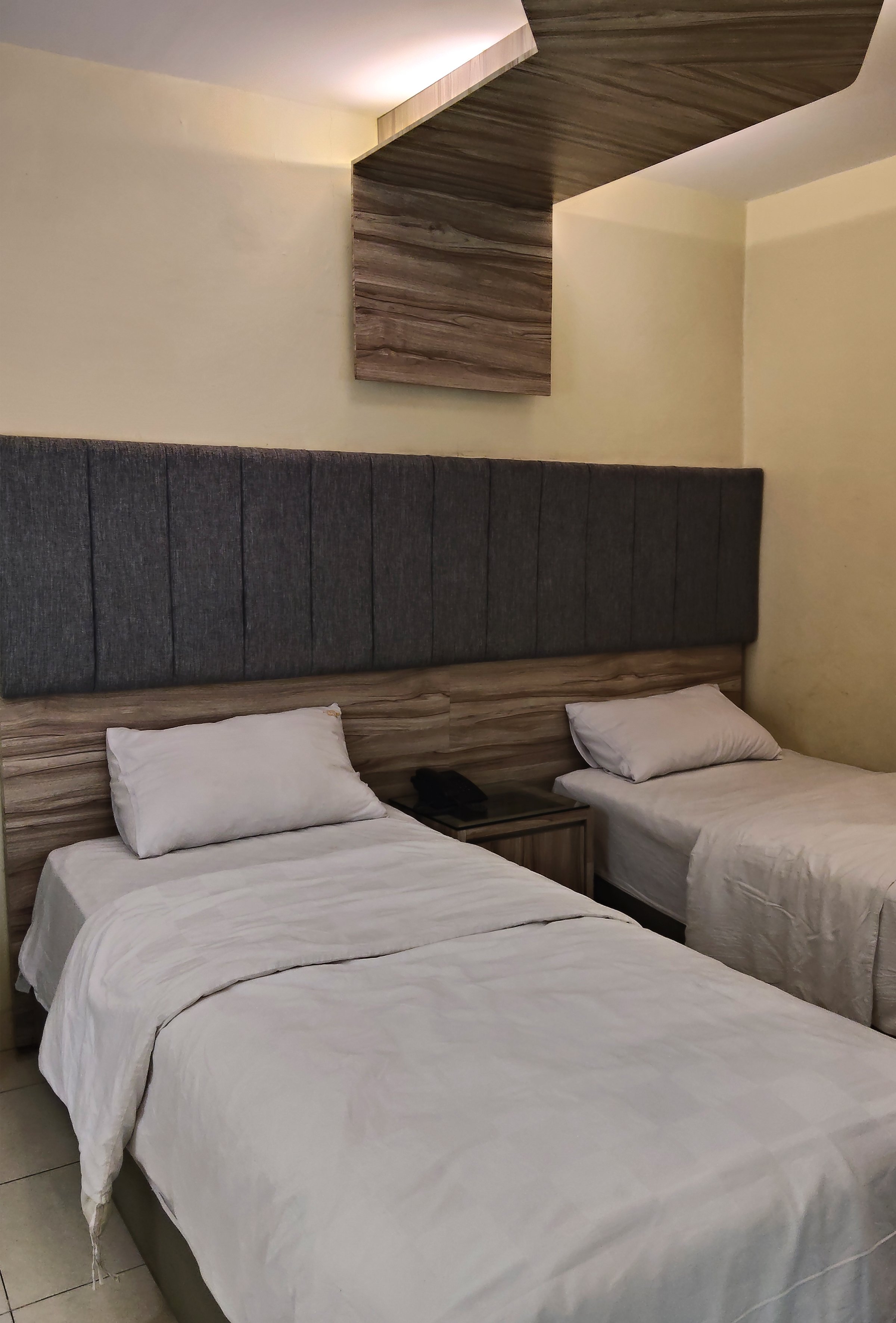 A comfortable and cozy modern hotel room featuring two twin beds, ready for a restful stay for travelers or guests.