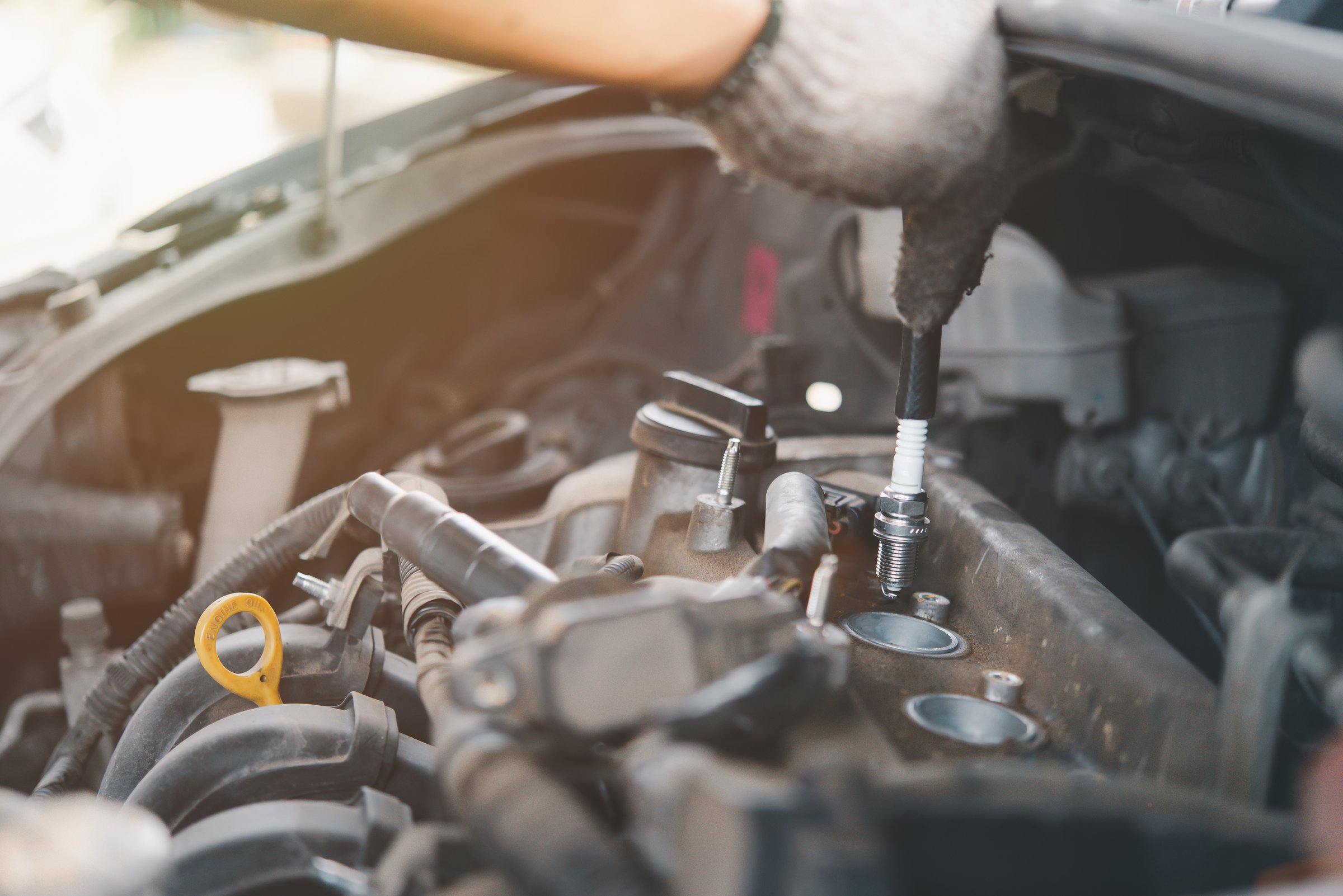 Mecánico quitando una bujía del motor de un automóvil