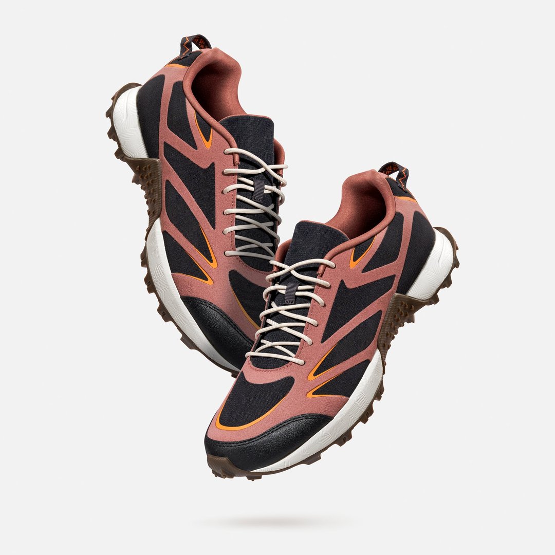 Stylish pair urban trail sneakers with textured sole and multicolor design levitation on light gray background. Concept of modern hybrid footwear for city trekking, comfort walking, active lifestyle