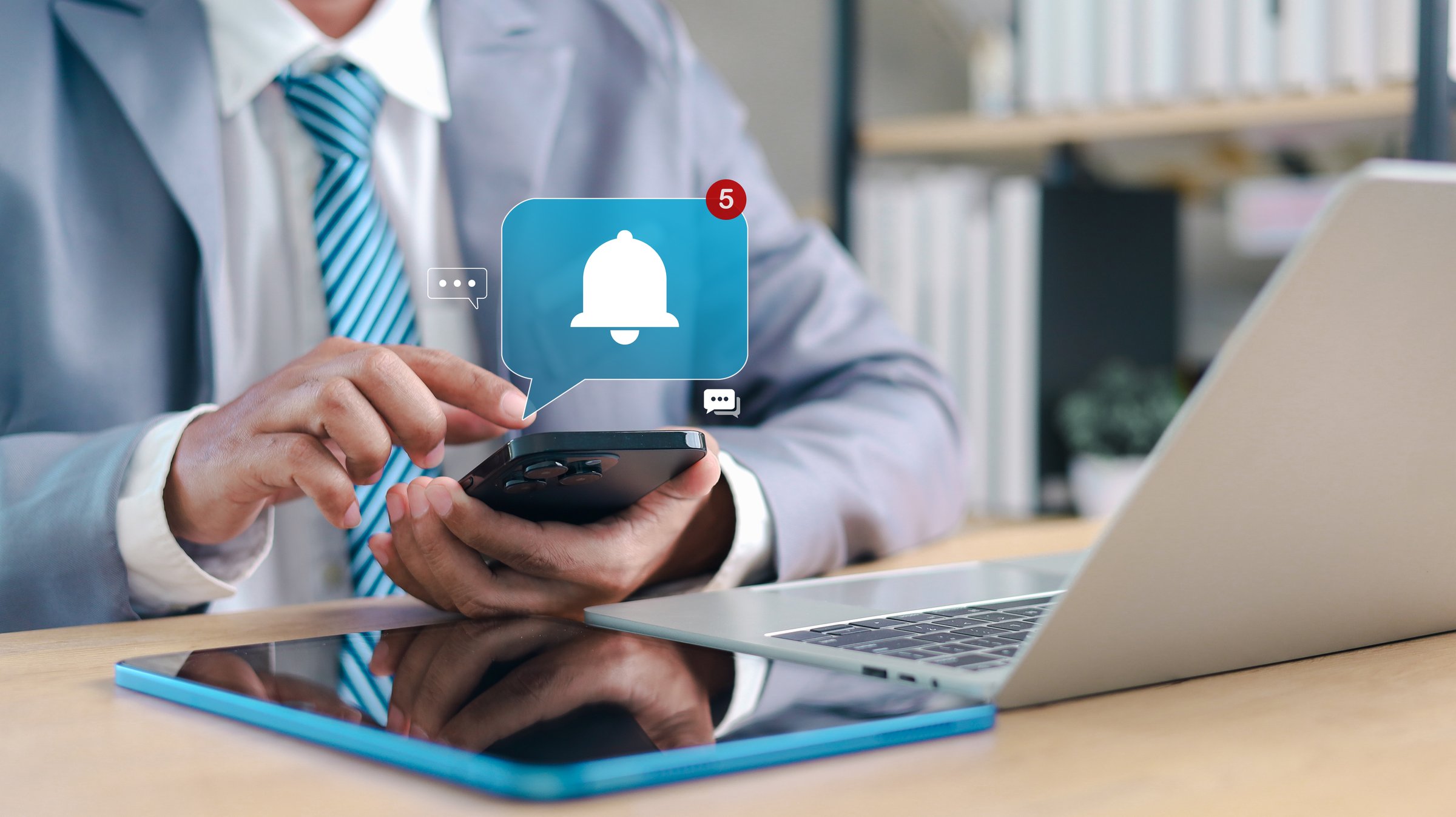 Business professional using smartphone with notification alert icon. Concept of mobile notification, digital communication, app alert.
