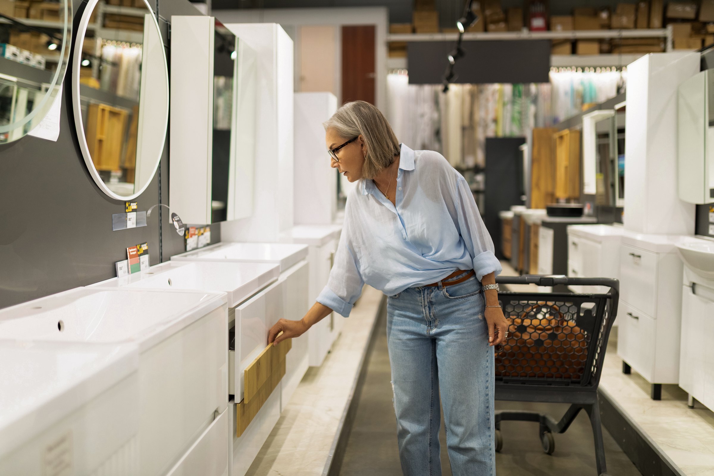 Middle-aged woman browses kitchen furnishings and decor in a home improvement superstore