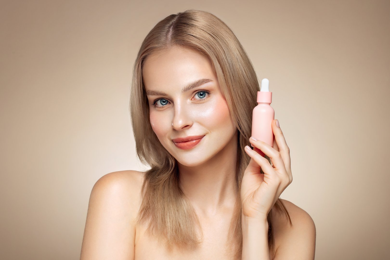 Beautiful blonde woman holding a cosmetic jar of oil serum or hyaluronic acid in her hand. Perfect facial skin