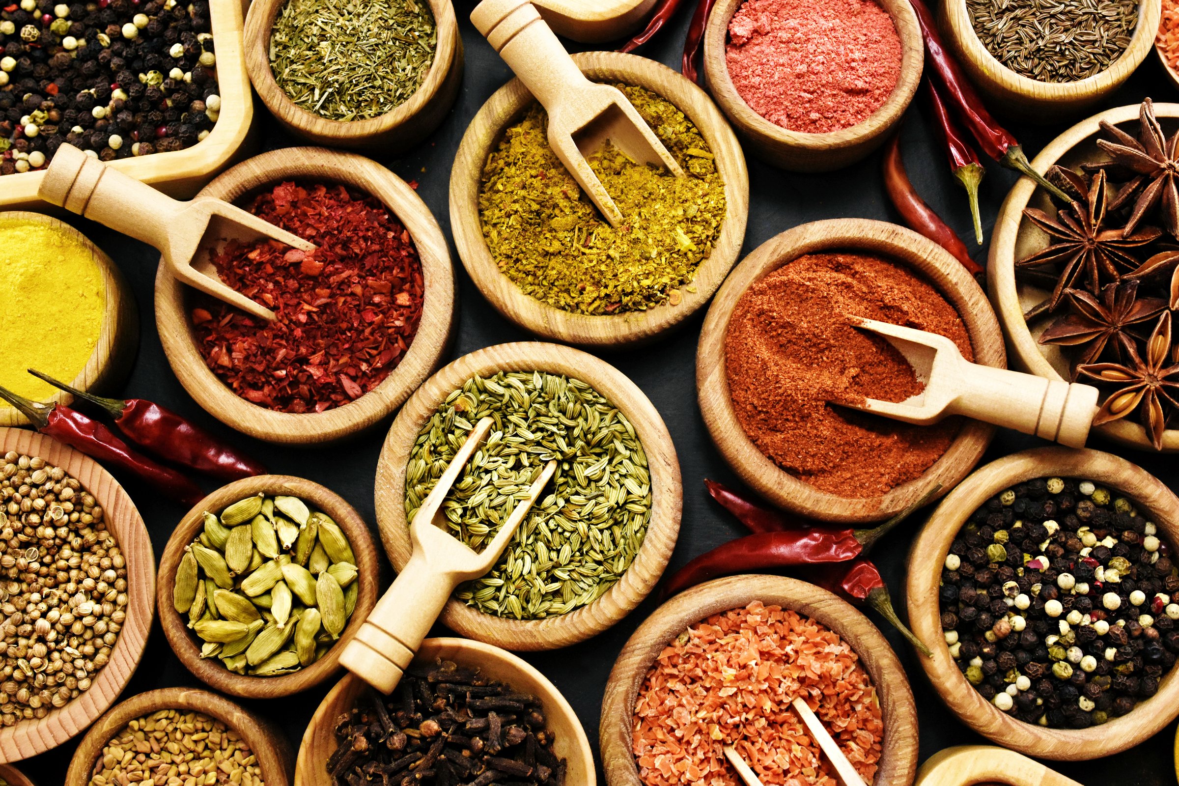 Colorful mix of herb and spice varieties: curry and coriander, turmeric and cumin, paprika and pepper, mustard and salt, cardamon and oregano and saffron. Selective focus, shallow DOF