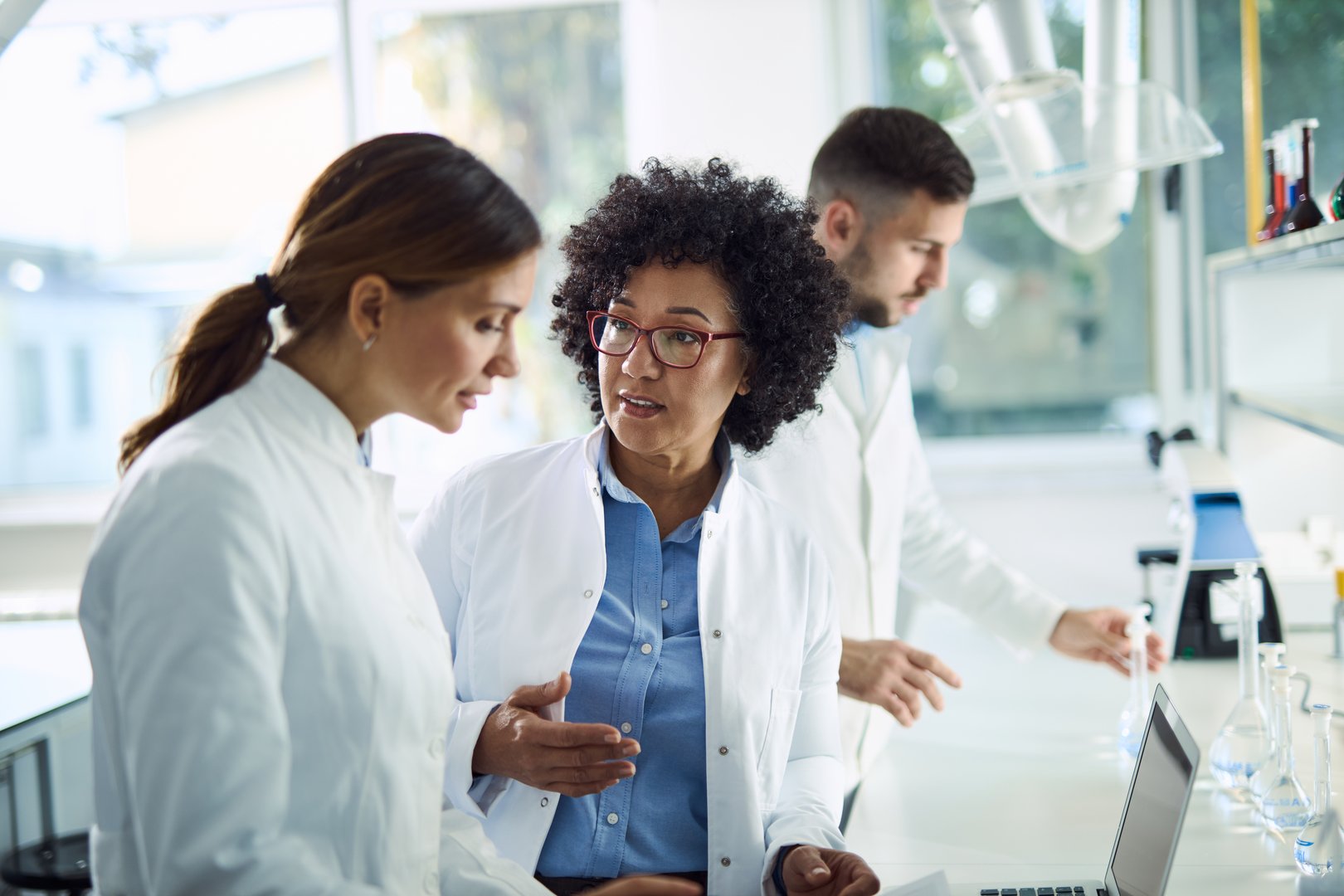 Two scientists talking while working together in laboratory.