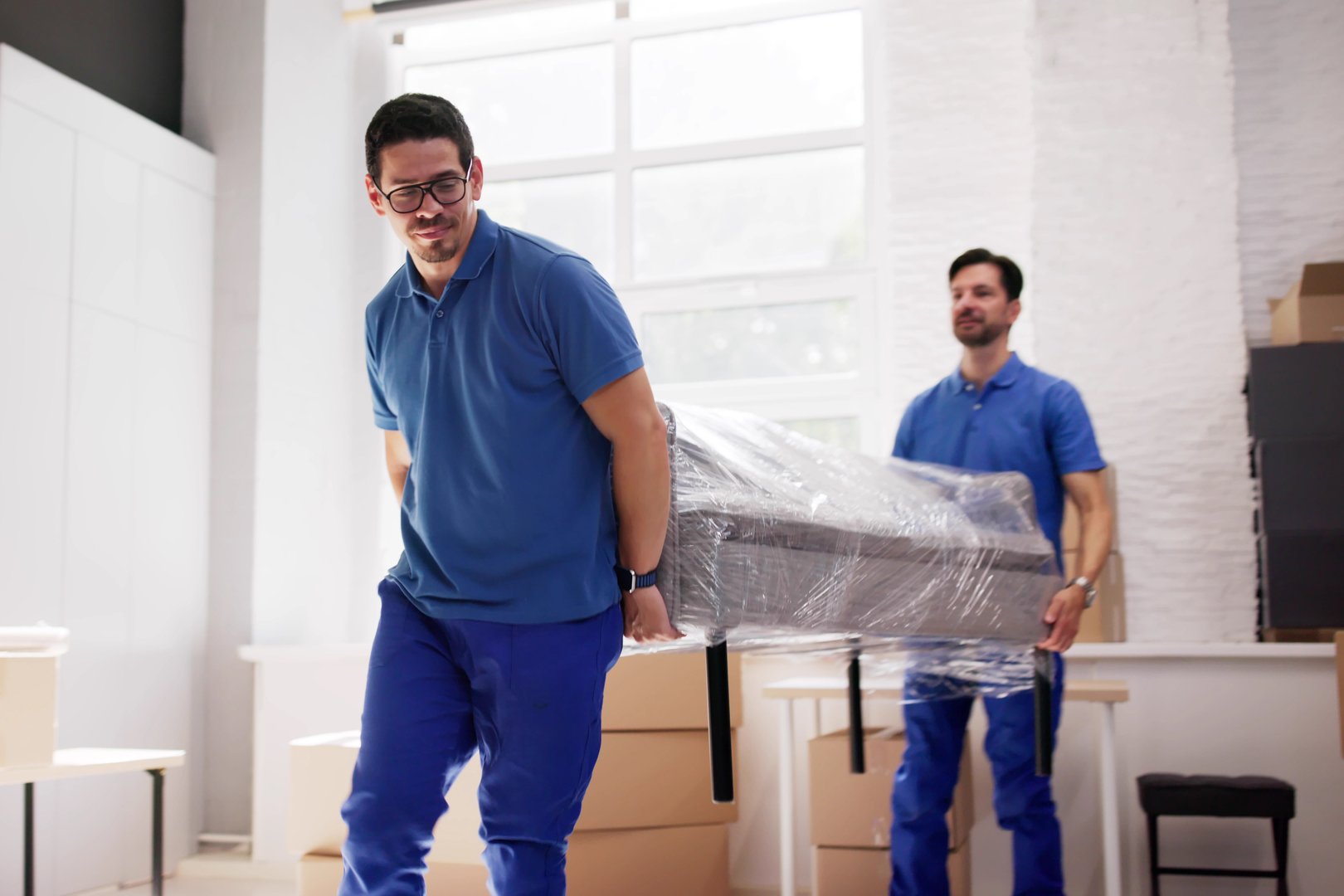Furniture Movers Expertly Carrying Sofa Through Living Room Doorway