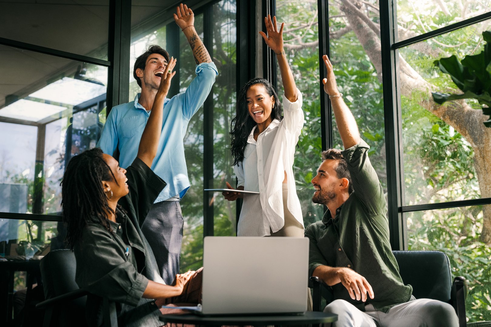 Group of successful multiethnic, diverse entrepreneurs and business people achieving goals together. They celebrate a successful project in office