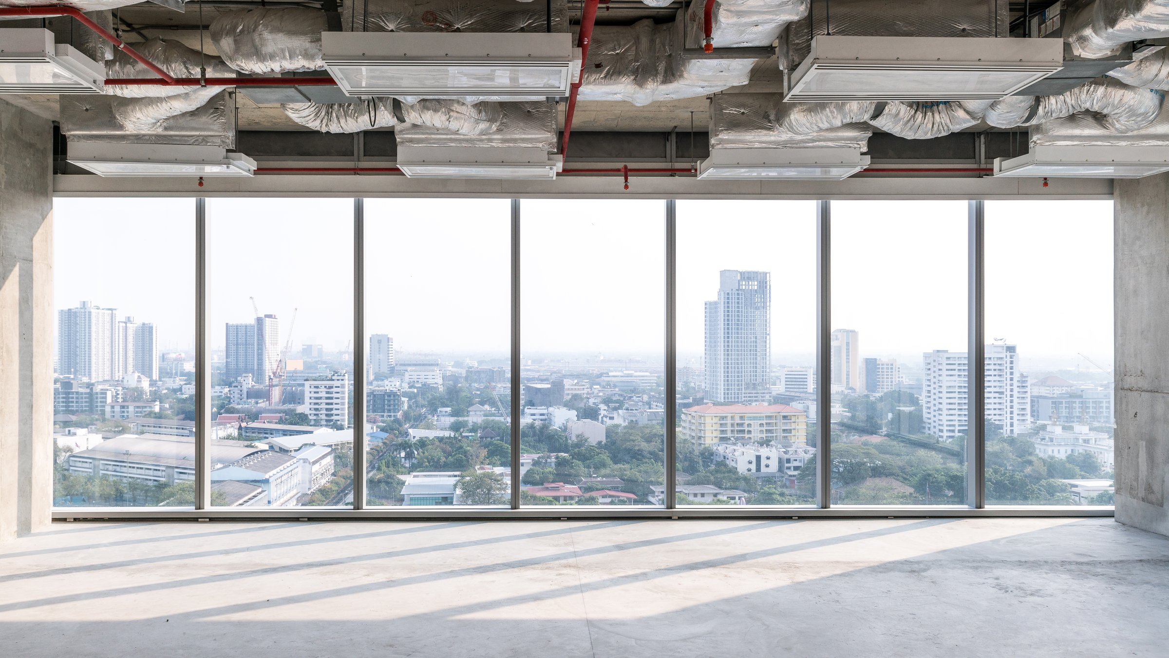 High rise office under construction with open ceiling structure and glass windows