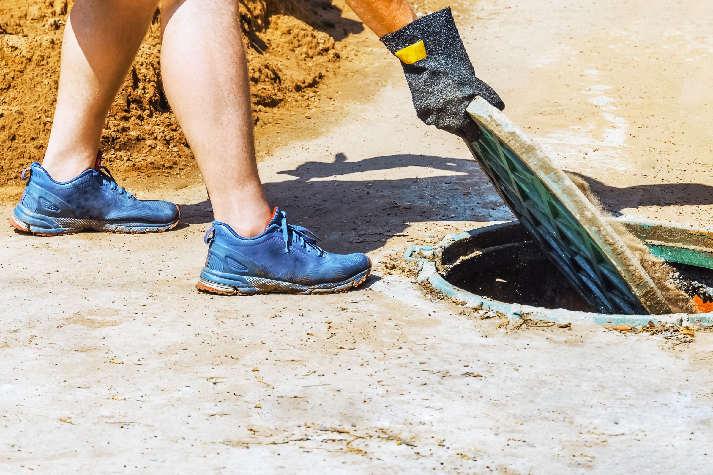 man pumping out house septic tank. drain and sewage cleaning service. Pipe in the drainage pit. Pumping out sewage from a septic tank. Septic tank service